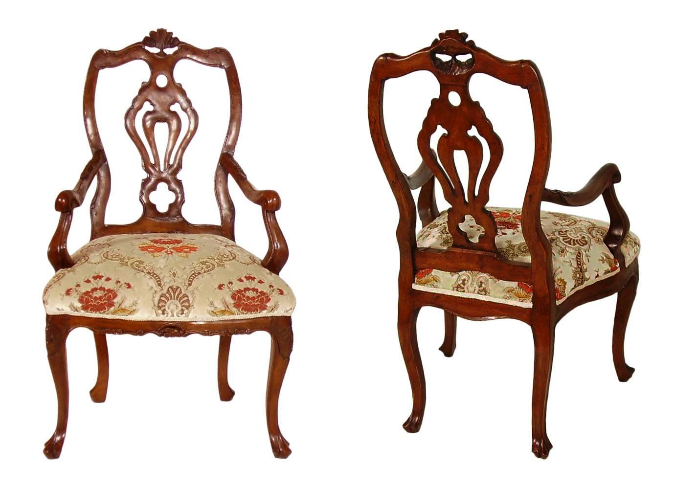 Code 

Pair of early 1700 Venetian Rococo armchairs have richly carved details. The backs have on top central carved shell while the armrests curve outward ending in carved C-scrolls. The chairs have front cabriole legs ending in carved feet. The