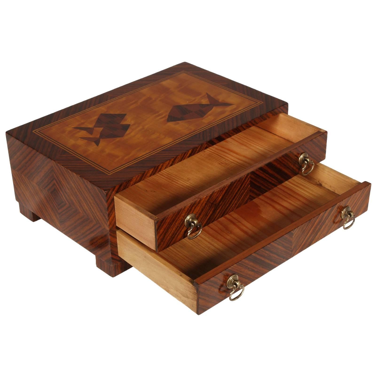 Code: FT02
Macassar ebony veneered jewelry box with precious rosewood striped herringbone, two drawers with brass handles. Top with maple veneer inlay figures.

Measure in cm H 12, L 30, P 19 in inches H 4.80, L 12.00                         , D