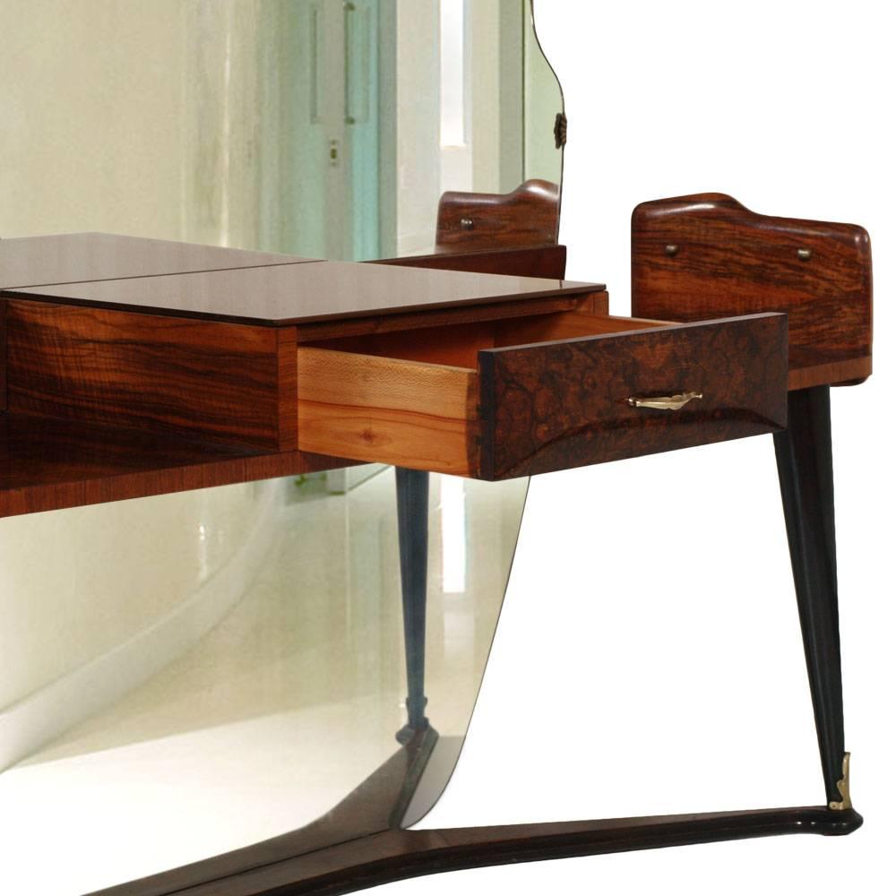 Code: FH27

Majestic vanity dressing table console with mirror, 1950s by Cesare Lacca per La Permanente Mobili Cantù , in burl walnut folder. Large shaped mirror. Console with two side shelves and centre drawer with beige glass and brass handle.