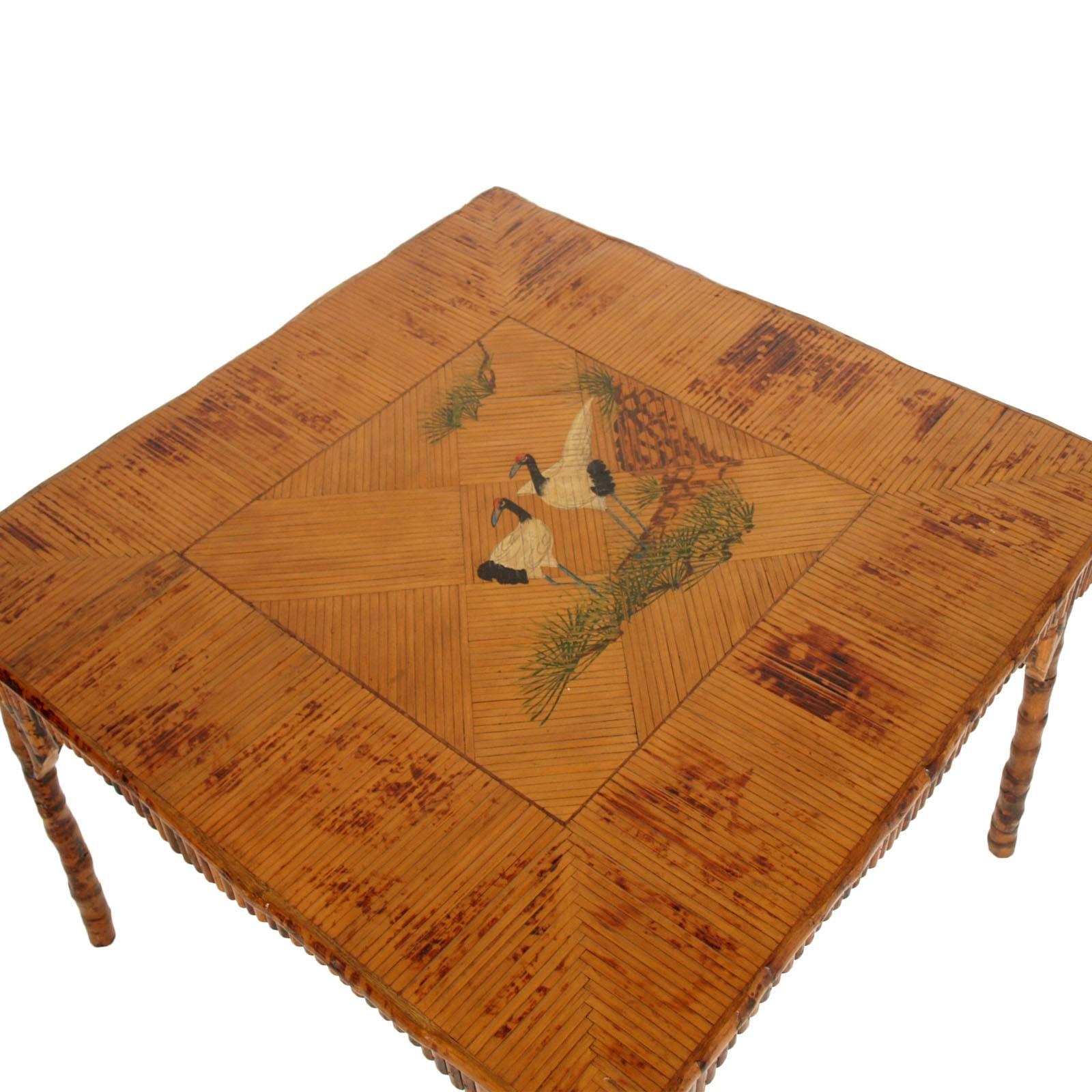 Wonderful Art Deco Chinoiserie table from the 1920s, in solid beech wood hand-carved in the shape of bamboo and decorated with bamboo-like decorations. Rattam table top applied in a checkerboard pattern with iridescent shades to form an exotic