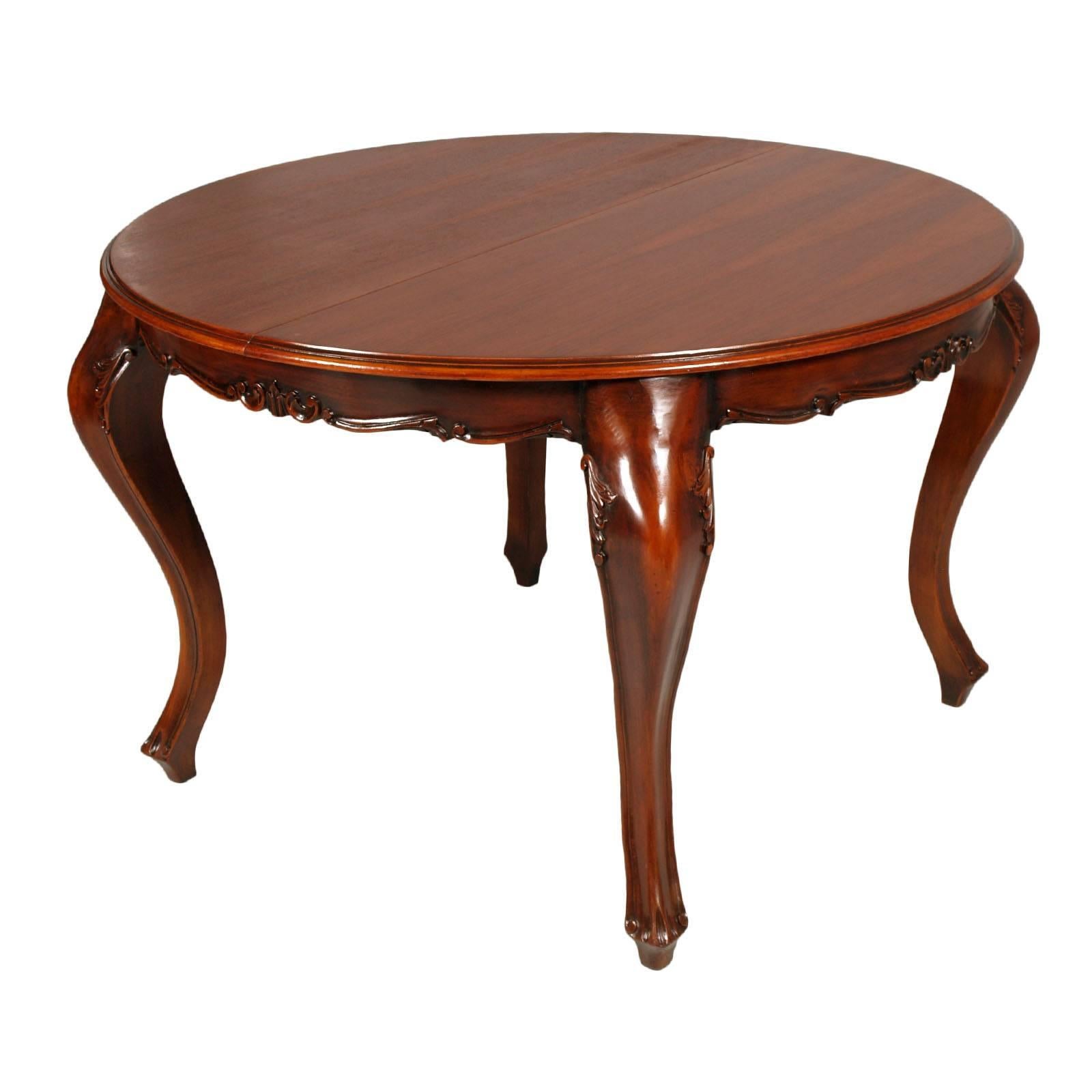 Early 20th century Revival Baroque extendable round table in hand-carved walnut with four Louis XV chairs in solid hand-carved walnut.
Table and chairs restored and polished to wax. 
Upholstery of chairs still in good condition, usable.
To