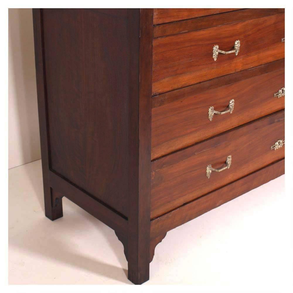 1910s period Art Nouveau chest of drawers commode dresser in solid walnut restored and polished to wax. 
The furniture is completely original with all its working accessories in silver bronze. The style is very simple and essential, but its ancient