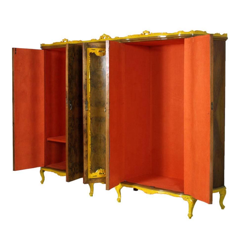 Precious 1930s Venetian Baroque cupboard wardrobe, by Testolini Freres Venice, in hand-carved walnut yellow decored and burl walnut, with central mirror . Interior upholstered in orange fabric velvet.

Measures cm: H 198, W 260, D 60.