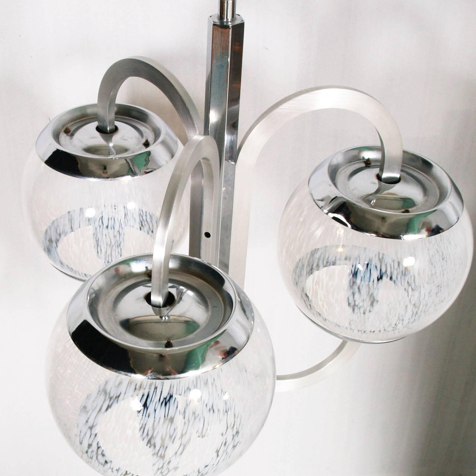 Lustre moderniste des années 1960 en acier chromé et aluminium avec trois grands verres de Murano Pulegoso 'BUBBLE', Carlo Steele attribuable.
Dimensions en cm : Hauteur 100, diamètre 55 (diamètre de la boule 20).
 