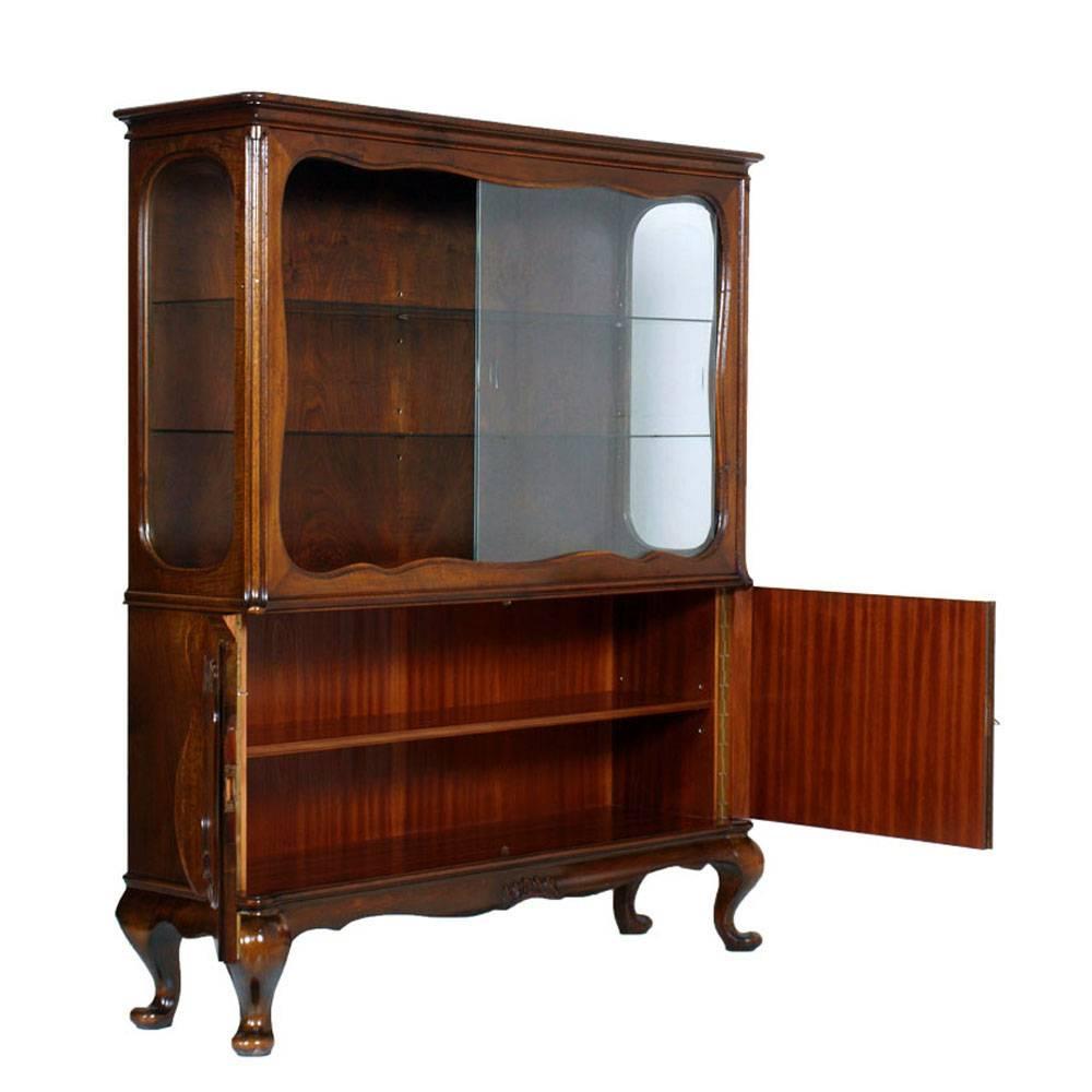 Venetian Baroque credenza display of the early 20th century in carved and shaped walnut. Two sliding glass doors with two glass interior shelves; two lower doors with frames covered olm roots and internal shelf. Classic Baroque feet. Internal