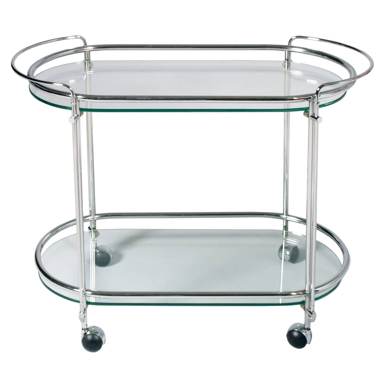 1950s Italian Mid Century bar cart in  chromed brass  and cristal , Gallotti e Radice attributed

This stylish two-tiered drinks trolley is in crystal and brass chrome and was made in the 1950s. It is oval shaped with four wheels chrome castors with