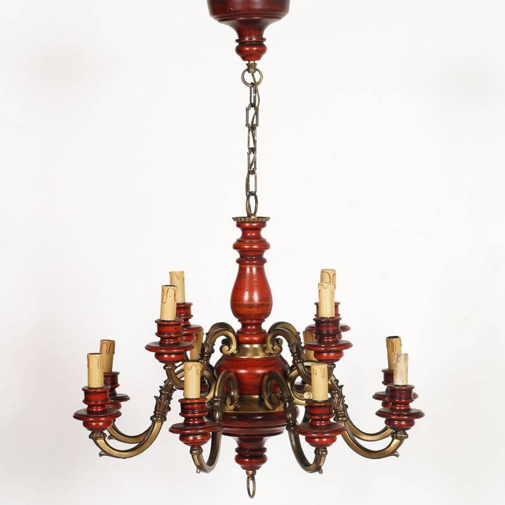 Midcentury Italian Florence Renaissance chandelier with twelve lights in burnished bronze and red lacquered wood.
Electrical system redone and working.

Measures in cm: height 100, diameter 70.