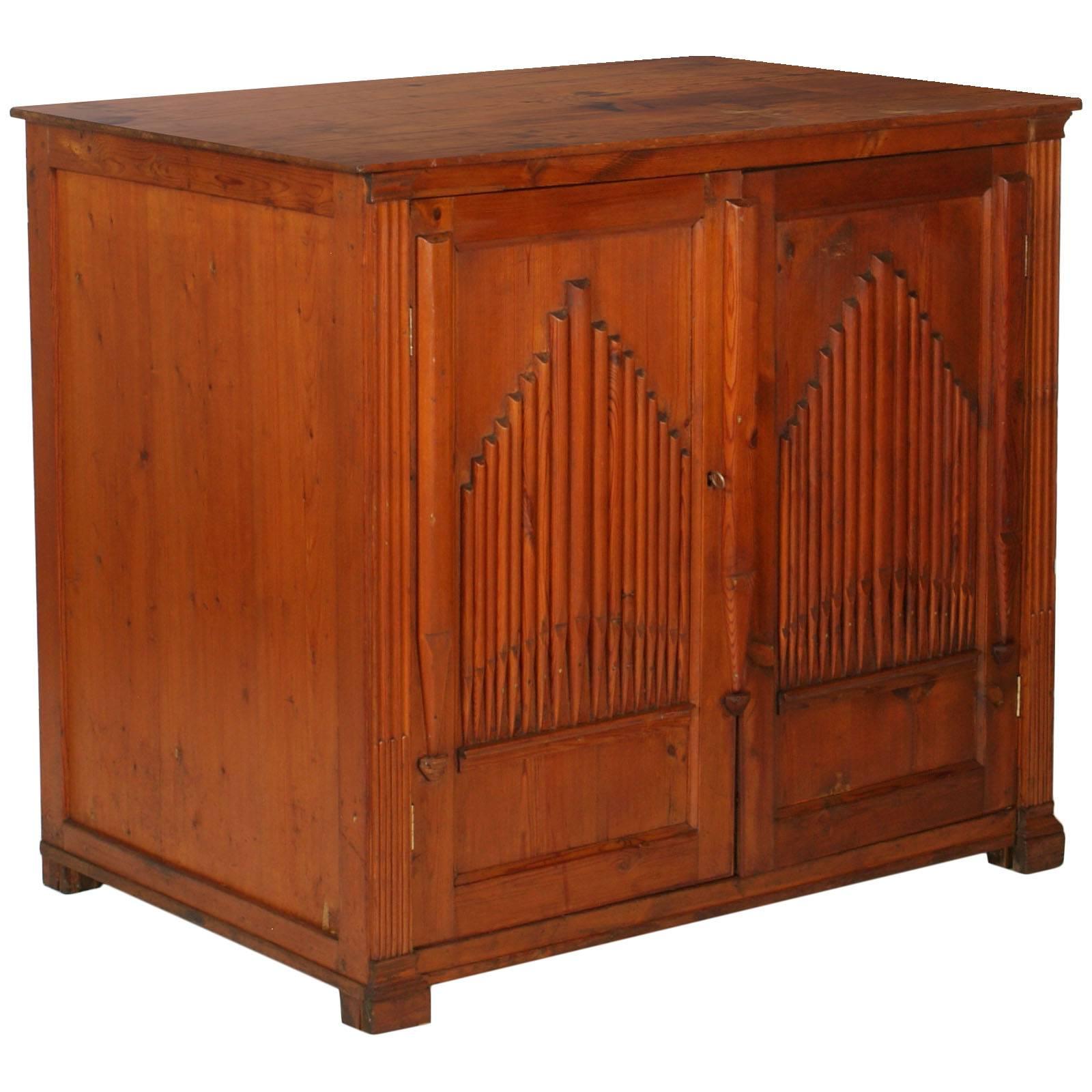 Sculptural sideboard in solid larch from the early 19th century. With two doors with musical organ decoration, squared and side slabs, with an internal shelf.
It comes from a church of Tuscany
Measure cm: H 100, W 112, D 73 

A beautiful piece