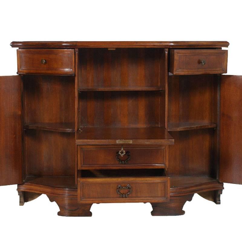 Buffet sideboard with flap in Renaissance style of the 1950s, in walnut and walnut folder. With two drawer sides, the central stage with internal shelf, two side doors with internal shelf, two large lower drawers and shaped socket.
Measures cm: W