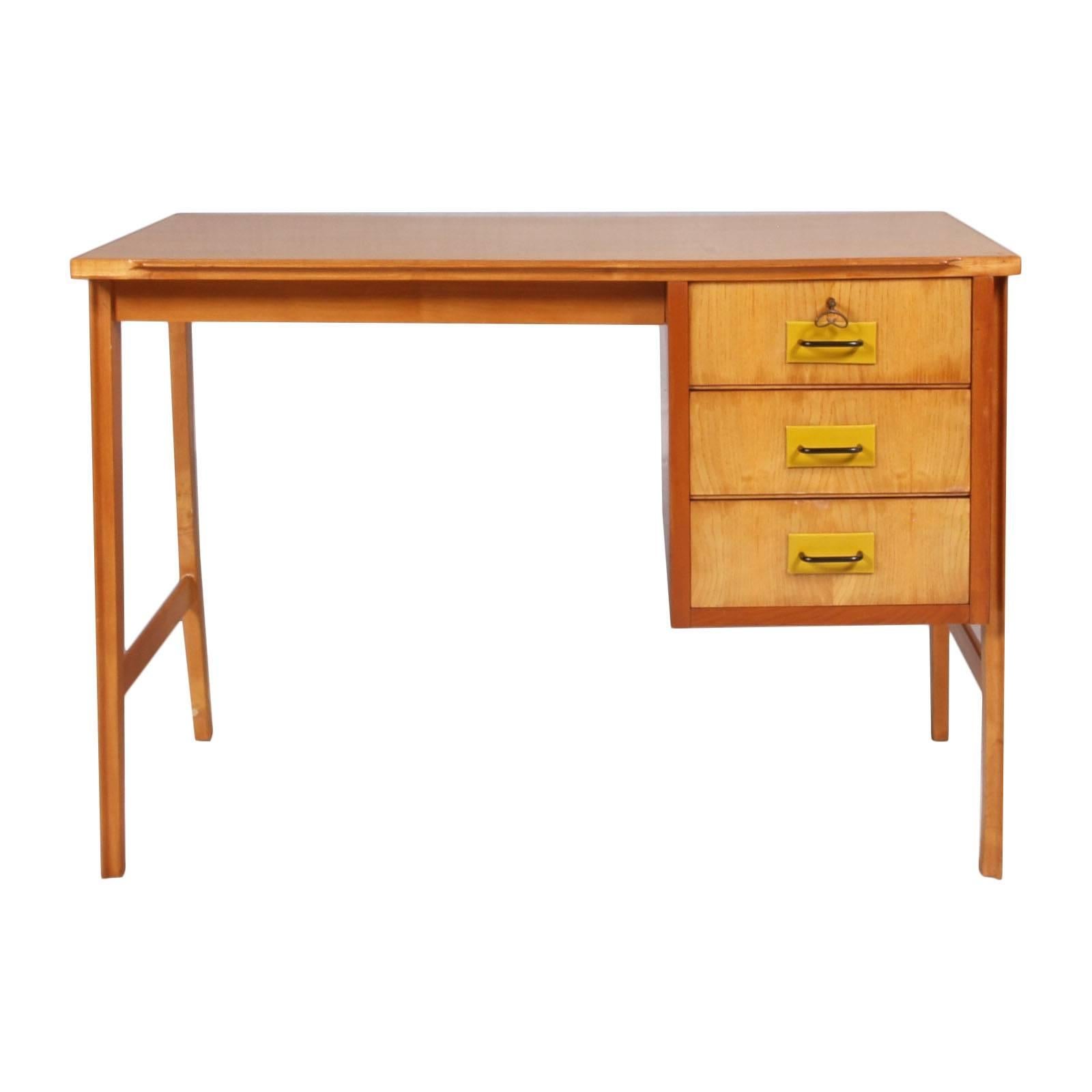 Mid-Century Modern Carlo di Carli writing desk in solid beech, maple,  and mahogany the bottom of the three drawers. Lacquered steel handles with leather 
Mobili di Cantù , cabinetmaker, labelled.
Excellent conditions.

Measures cm: H 78 x W 110 x D