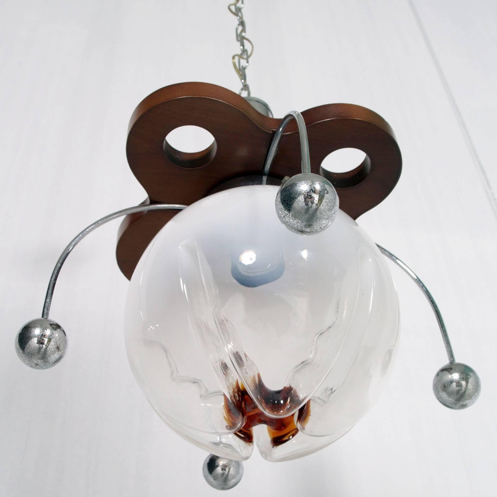 Ceiling lamp in the manner Italian designer Gaetano Sciolari. Wood and chrome-plated metal structure, with four arms as electrons with Murano glass globes. Manufactured by Mazzega Glass Factory (1929-1983) in the 1960s. Good condition with electric