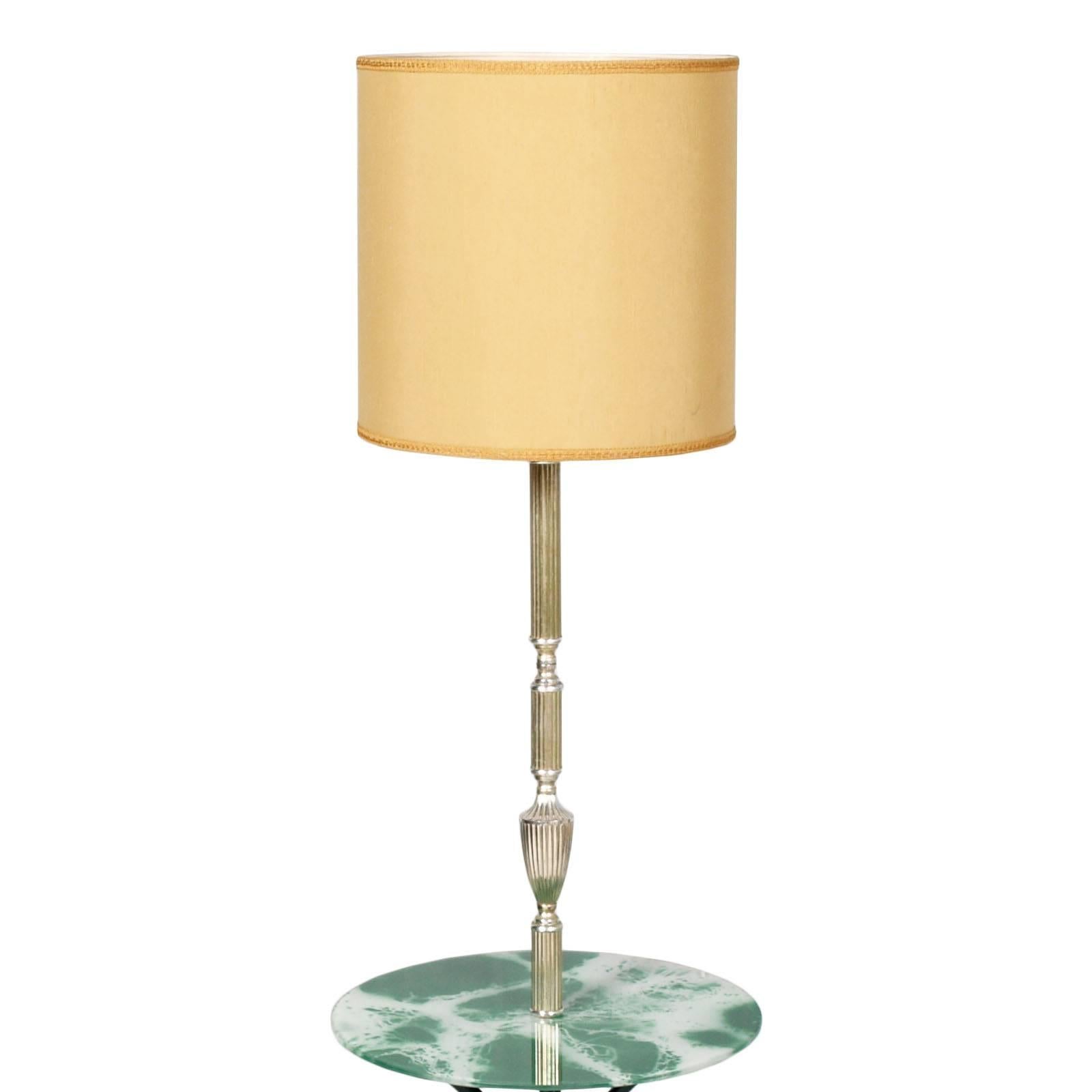 Ce lampadaire moderne de style Gio Ponti a trois pieds en acier verni noir, une tige en laiton argenté, caractéristique de la période Art Déco. La table est en faux marbre vert décoré de cristal
Système électrique en conformité. Utilisable