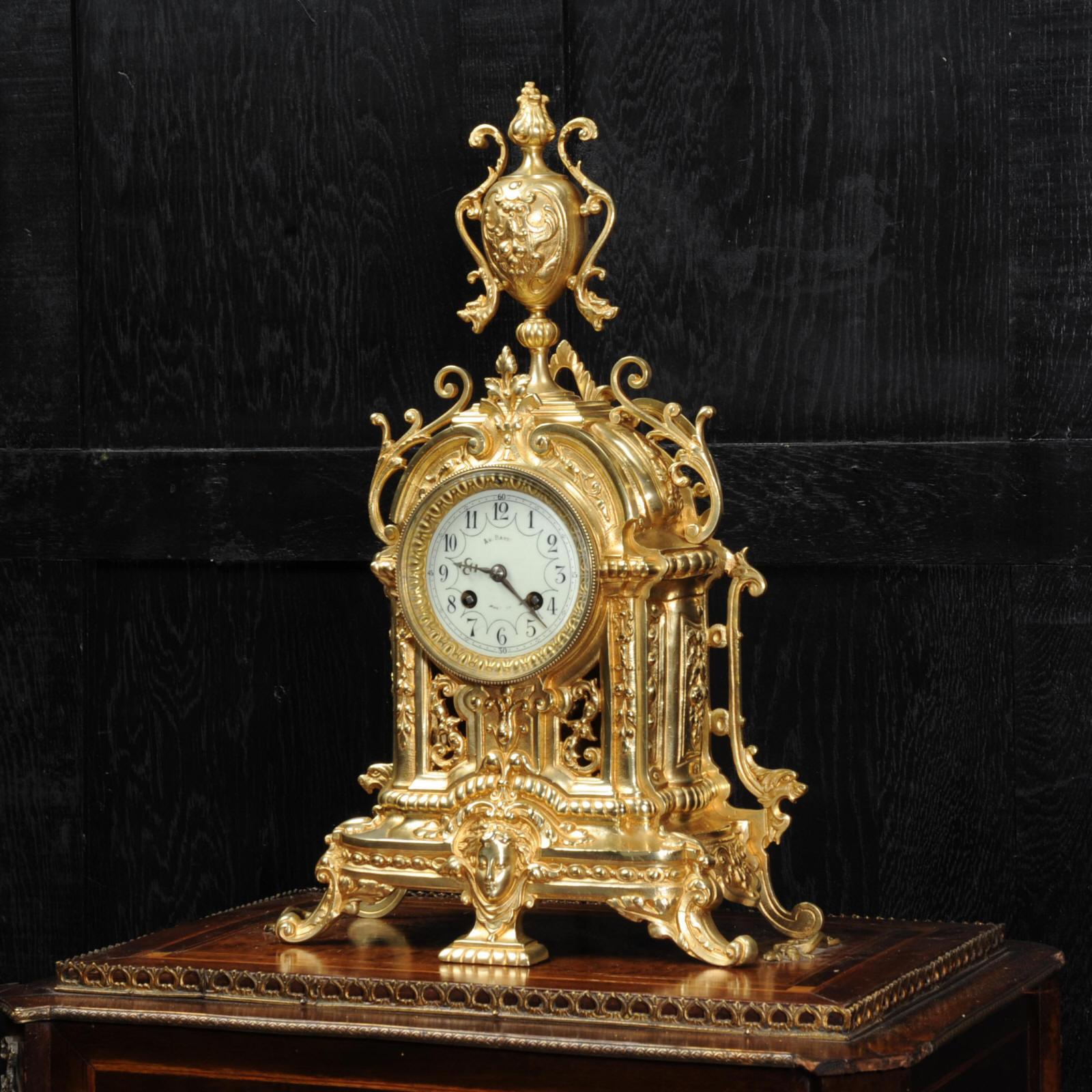 A lovely original antique French gilt bronze clock, circa 1890, beautifully modelled in the Baroque style. Decorated with scrolling acanthus, a goddess mask and a large, elaborate urn. The front is fretted to lighten the design and allow a glimpse