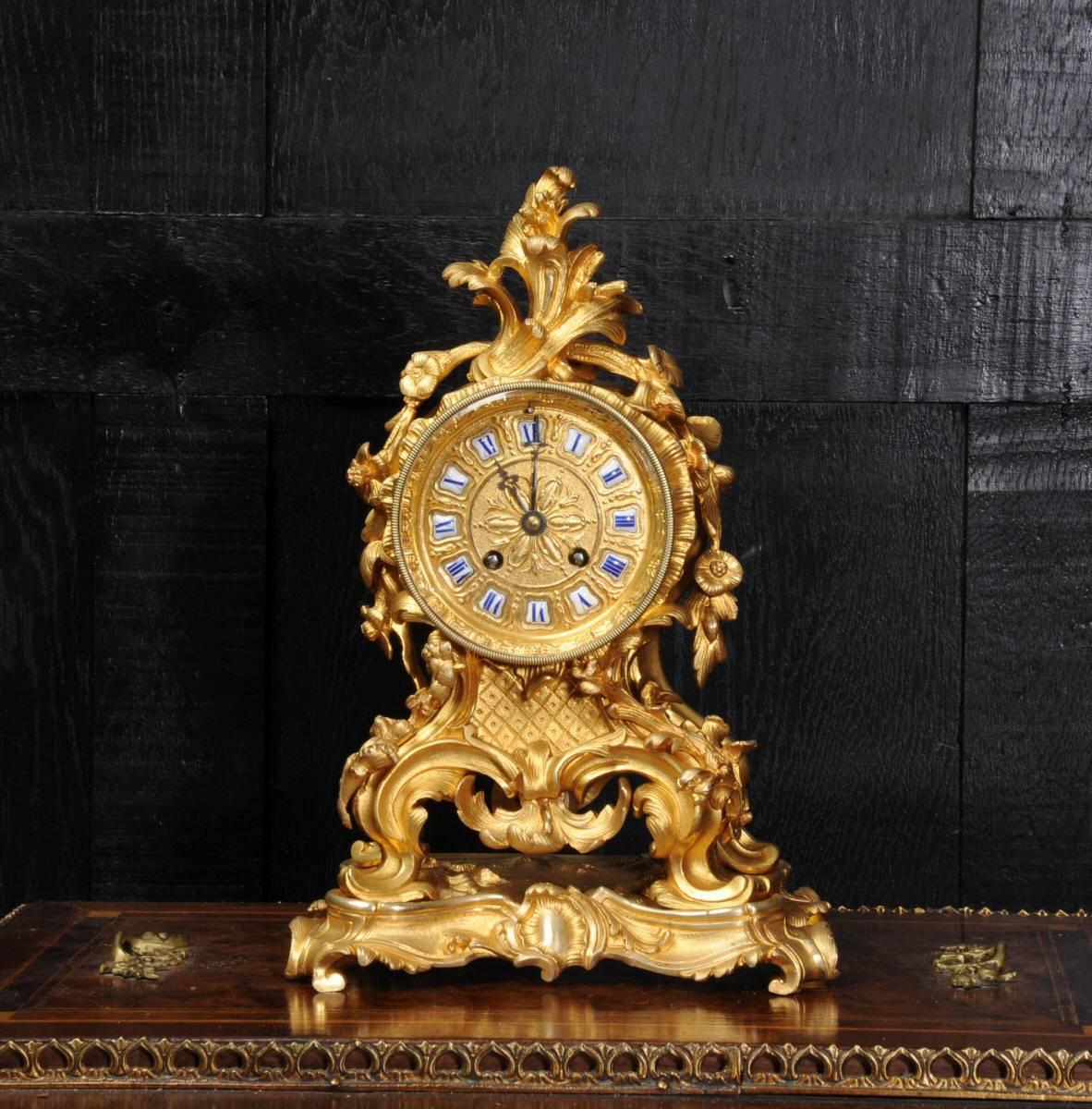 A fine and early ormolu (mercury gilded bronze) boudoir clock of small and delicate proportions. It is Rococo in style, decorated with elaborate flowing foliage, scrolls and floral swags. The gilding is in lovely condition, we have carefully removed