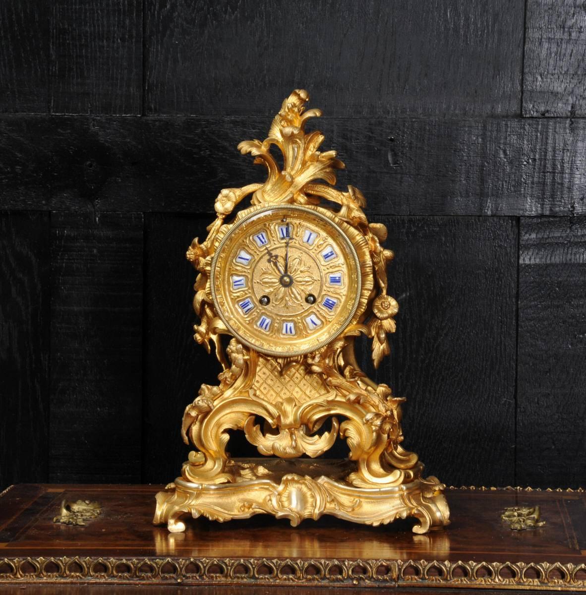 A fine and early ormolu (mercury gilded bronze) boudoir clock of small and delicate proportions. It is Rococo in style, decorated with elaborate flowing foliage, scrolls and floral swags. The gilding is in lovely condition, we have carefully removed