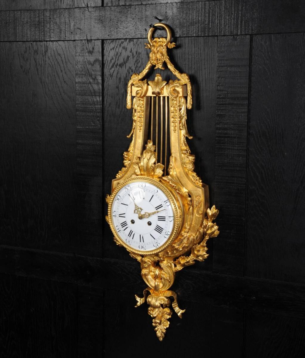 A magnificent large antique French lyre wall clock, exquisitely made in ormolu (finely gilded bronze or Doré Bronze). It is modelled in the Classic style of Louis XVI in the shape or a large (30" high) lyre with acanthus decoration. The quality