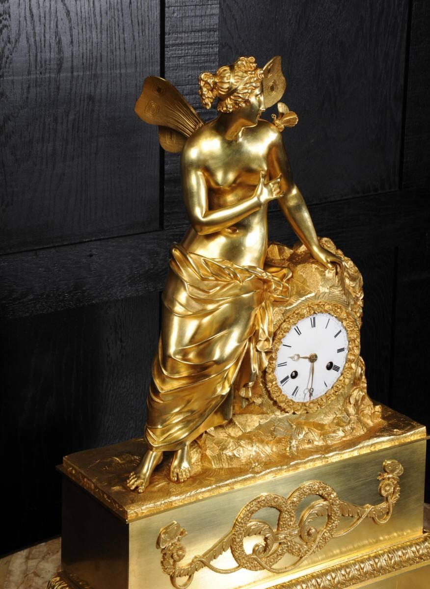 A fine and early French Empire ormolu (mercury fire gilded or bronze doré) clock. The original gilding is in exquisite condition with a lovely golden glow. The clock depicts the goddess Psyche with a butterfly gently resting on her shoulder, seated