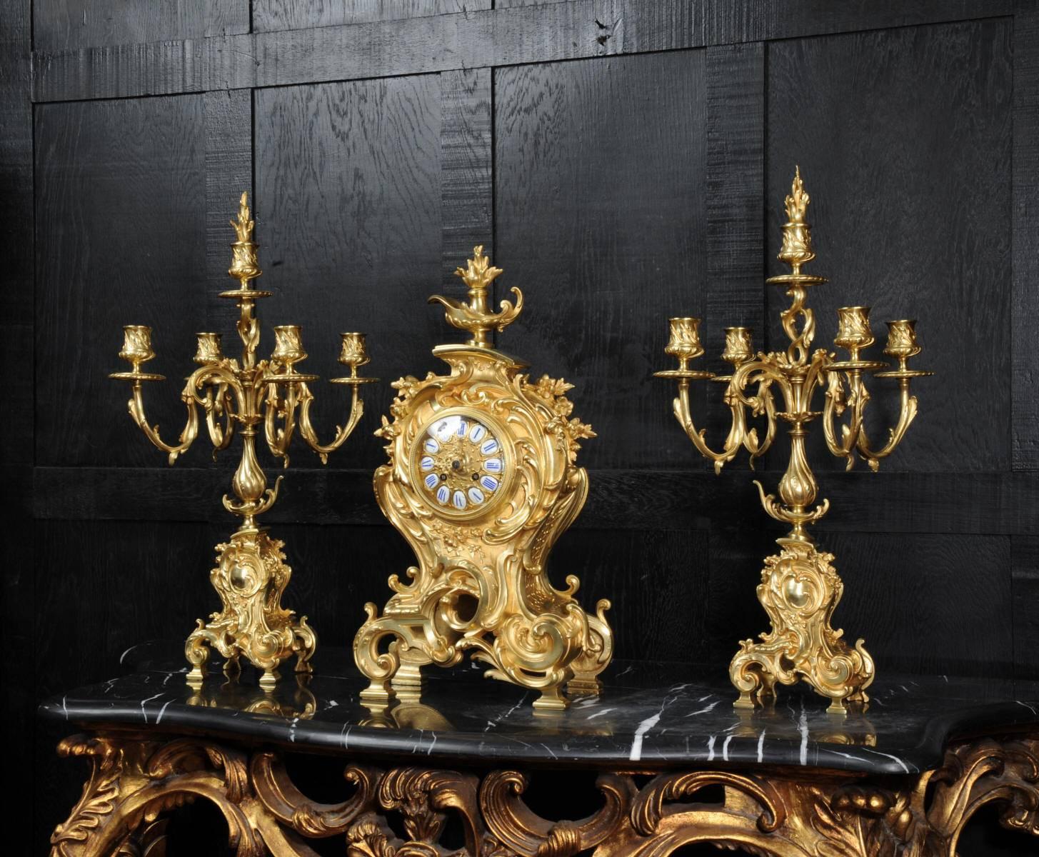 A large and stunning antique French gilt bronze clock set by Japy Freres, fully overhauled and working. It is Rococo in style, a bold, asymmetric balloon shape profusely decorated with acanthus and floral swags. To the top is a flaming finial, the