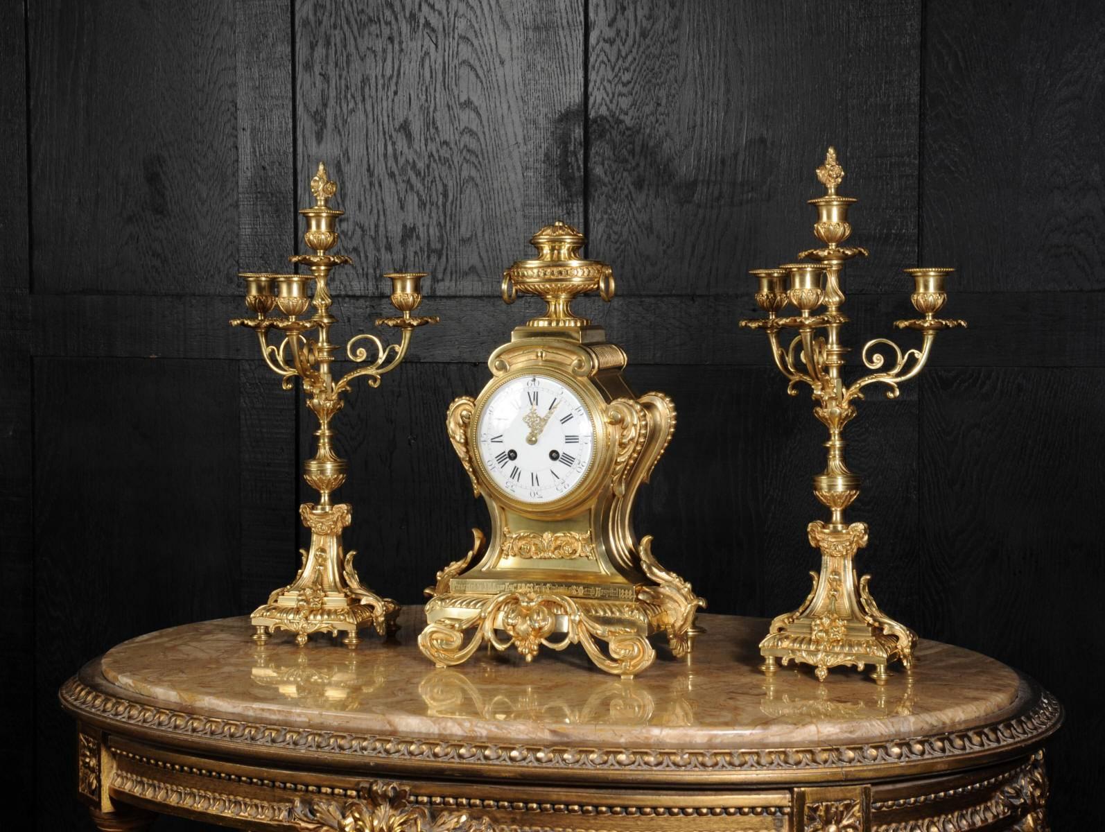 A beautiful, fully working, original antique French bronze clock set dating from circa 1888. It is modelled in the Louis XVI style, restrained and chic with a waisted case decorated with floral and acanthus decoration.

Candelabra have three