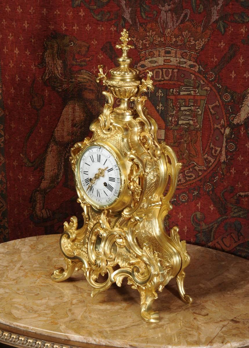 A stunning and very large original antique French gilded bronze clock. It is of the most beautiful Rococo style, asymmetric wasted case decorated with 'C' scrolls, acanthus leaves and floral swags. To the top is a large elaborate urn with acanthus
