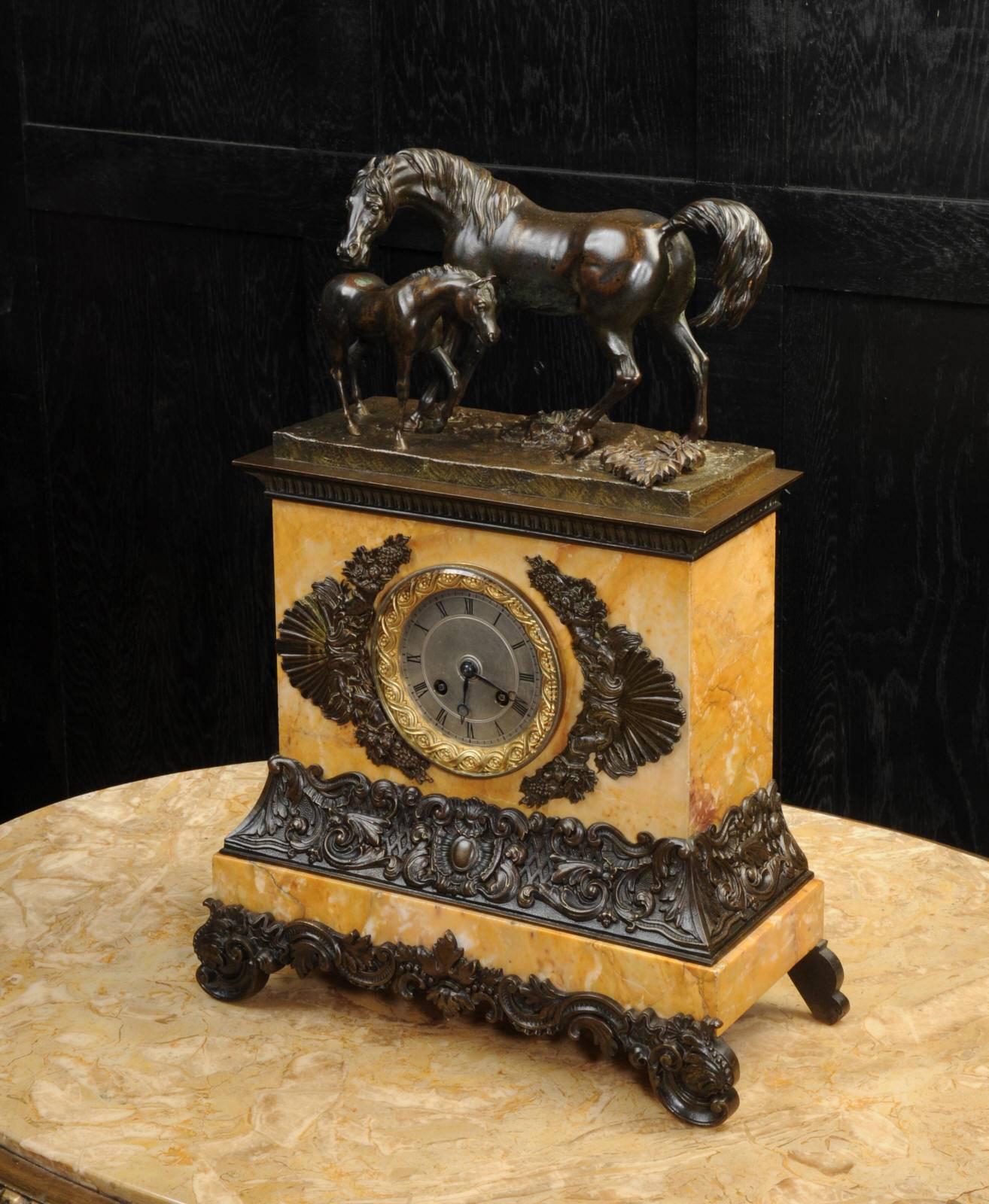 A beautiful, original and early clock depicting a mare tending her foal. Beautifully and delicately modelled in bronze, full of life and movement with a lovely antique patina. The clock is mounted in a Sienna marble plinth mounted with crisp bronze