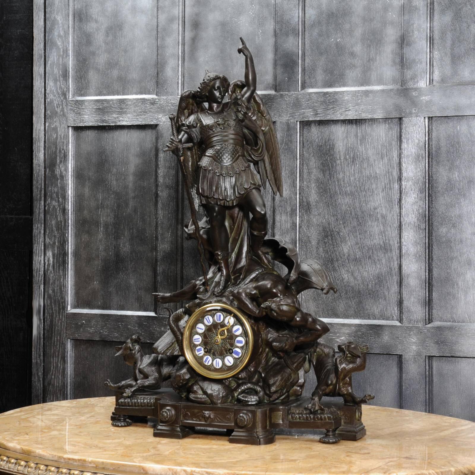 A rare and superb sculptural clock depicting St Michael Slaying the Devil. Exquisitely modelled in bronze patinated white metal, it shows St Michael standing triumphantly above the slain Satan, hounds baying to each side. A snake entwined around his
