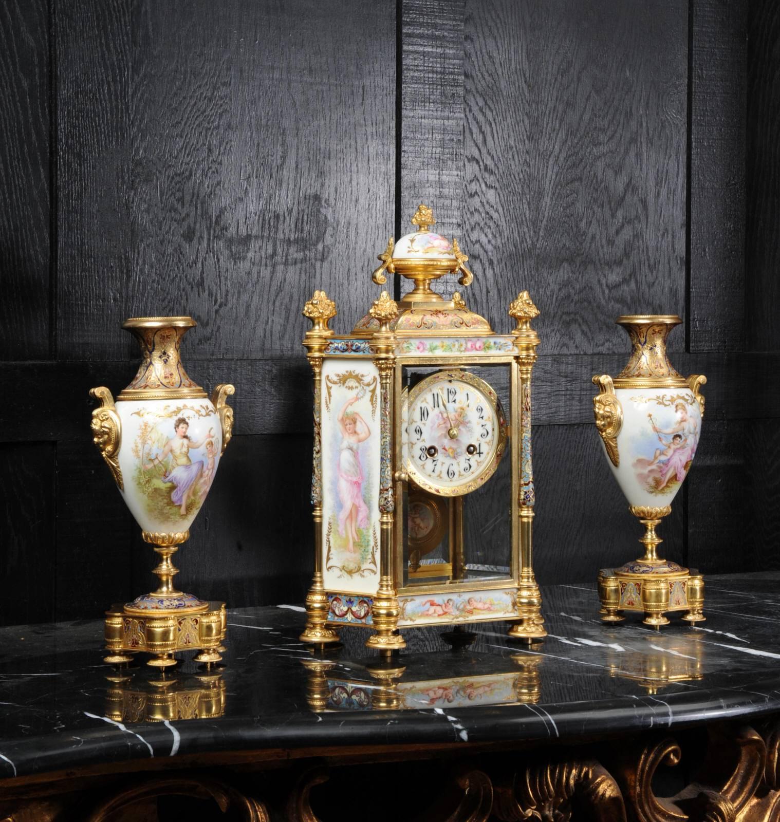A rare and beautiful antique French clock garniture, in excellent original condition. Ormolu (fine gilded bronze) is mounted with exquisitely painted Sèvres style porcelain and inset with rich champlevé enamel. Porcelain is very finely painted with
