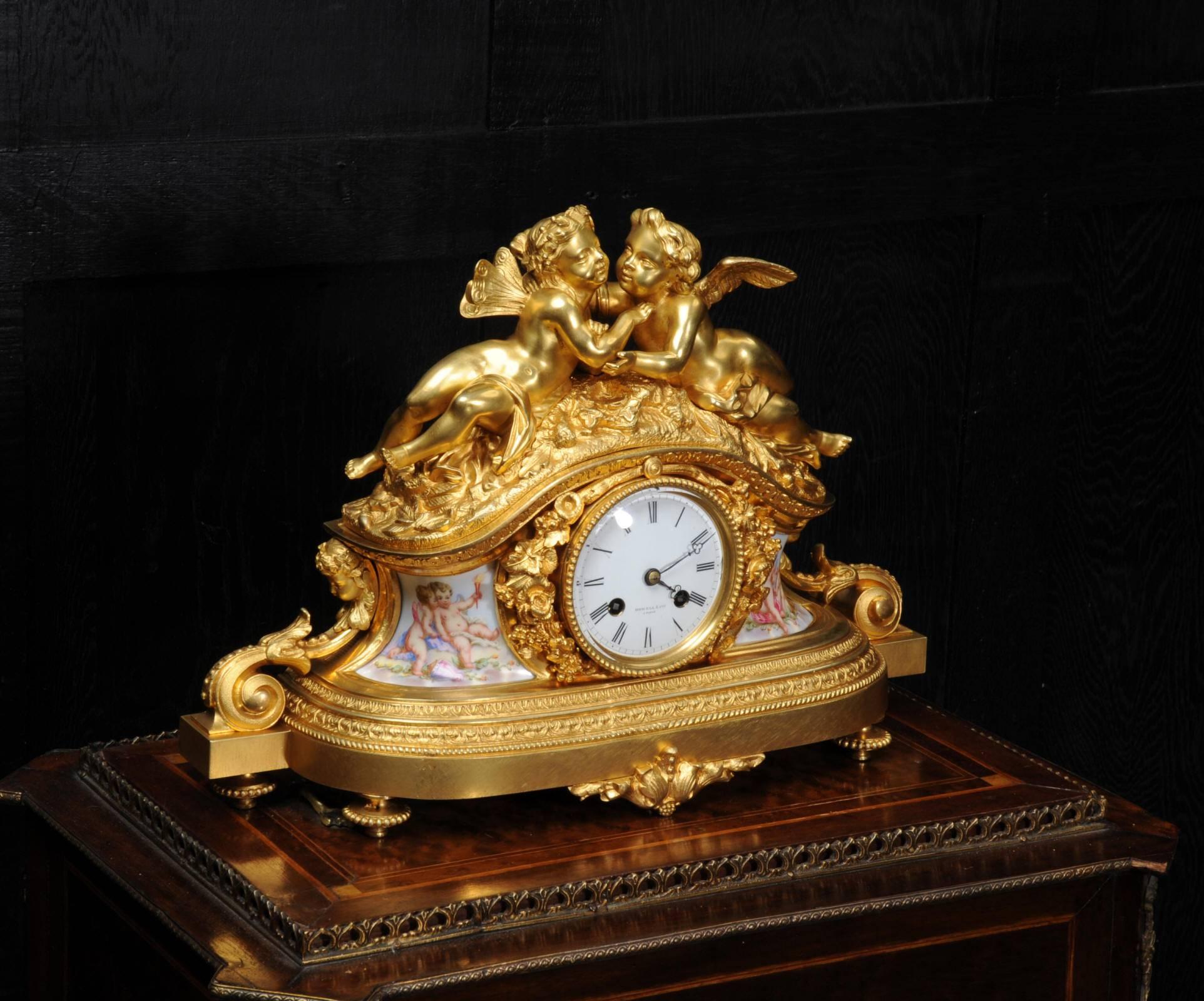 A fine and early clock featuring the most charming cherubs, modelled in fire gilded bronze (bronze doré). To the base are a pair of exquisitely painted porcelain panels also featuring cherubs. The clock was retailed by the famous Howell James and