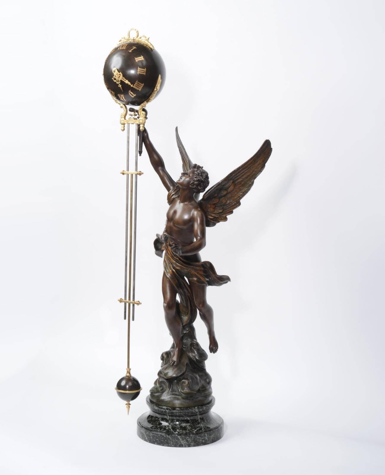 Standing at 3 1/2 ft in height this is the rare large version of the French swinging mystery clock. The figure is La Victoire by Émile Bruchon, beautifully and boldly modelled in bronze patinated metal. He holds a loft the pendulum which swings