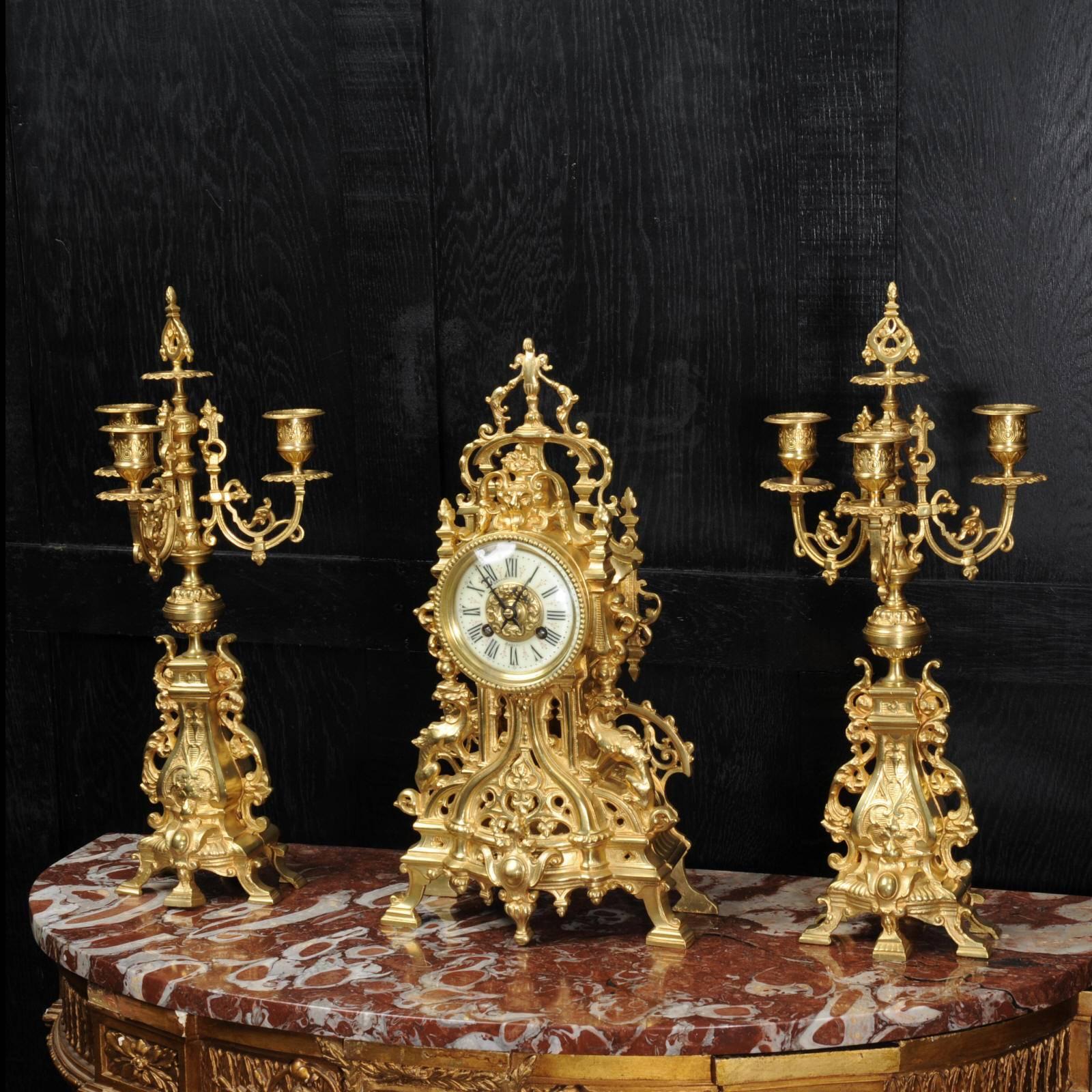 A stunning original antique French clock set by Samuel Marti dating from circa 1870. It is beautifully modelled in gilt bronze, Gothic in style with a light and delicate design of fretwork. This allows the pendulum to be seen swinging gently inside