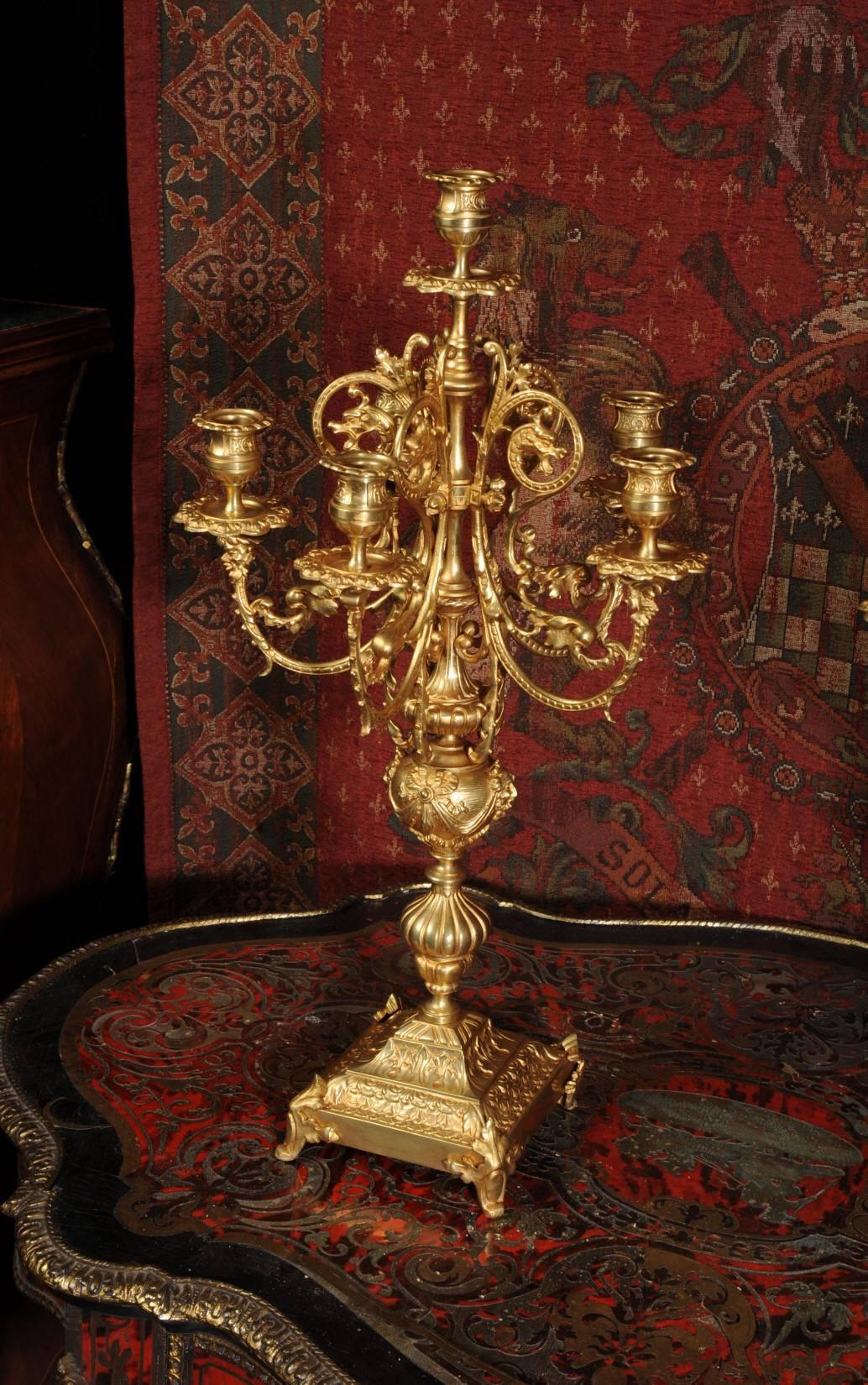 A superb pair of gilt bronze candelabra. Dating from circa 1880 and French, they are Baroque in style with sweeping arms with mythical masks supporting the five lights with a further light to the center.
