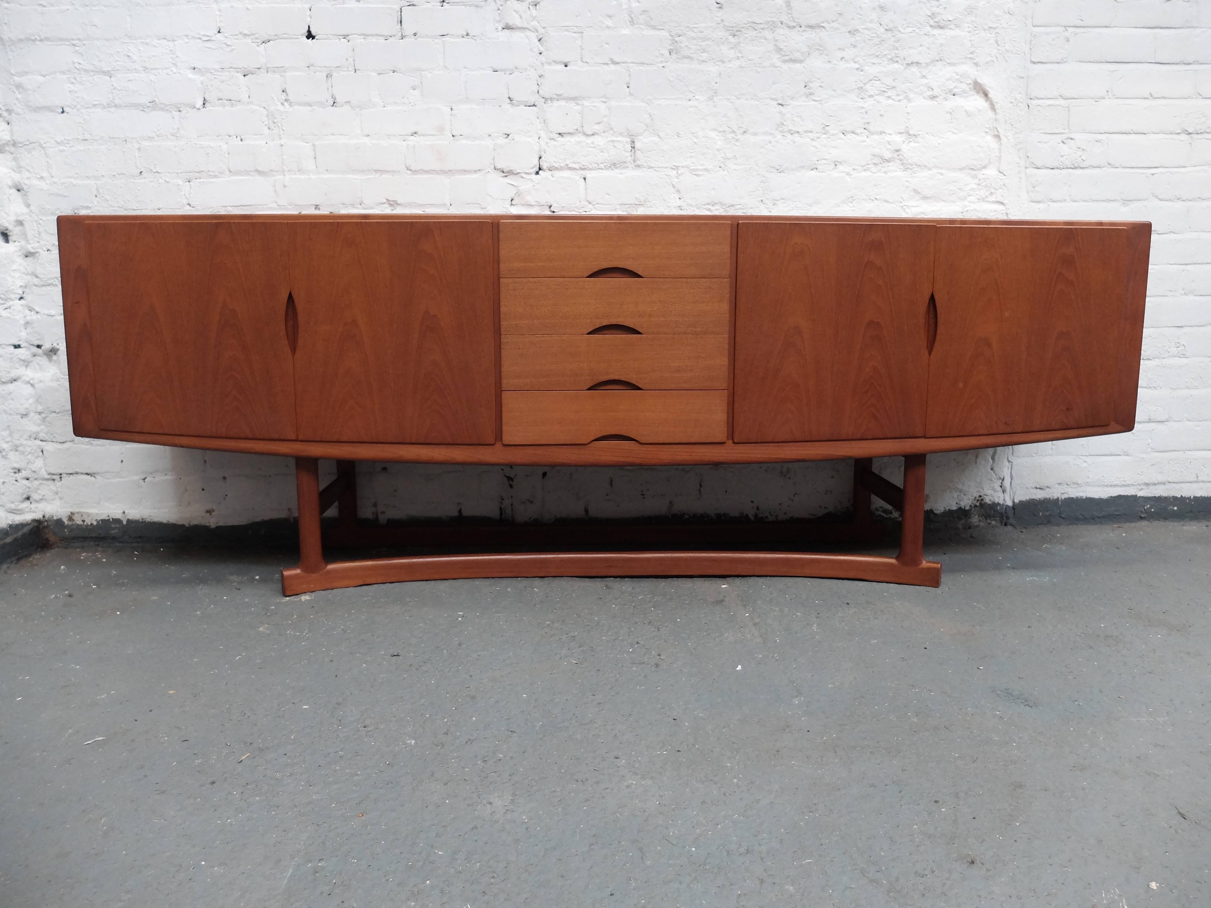 Stunning vintage teak sideboard by Johannes Andersen for Hans Bech. 
Model number HB20.
Made in Denmark
Subtle curves and strong teak grain, stylish and functional. 
Four drawers to the centre, two are felt lined.
Cupboards either side, one