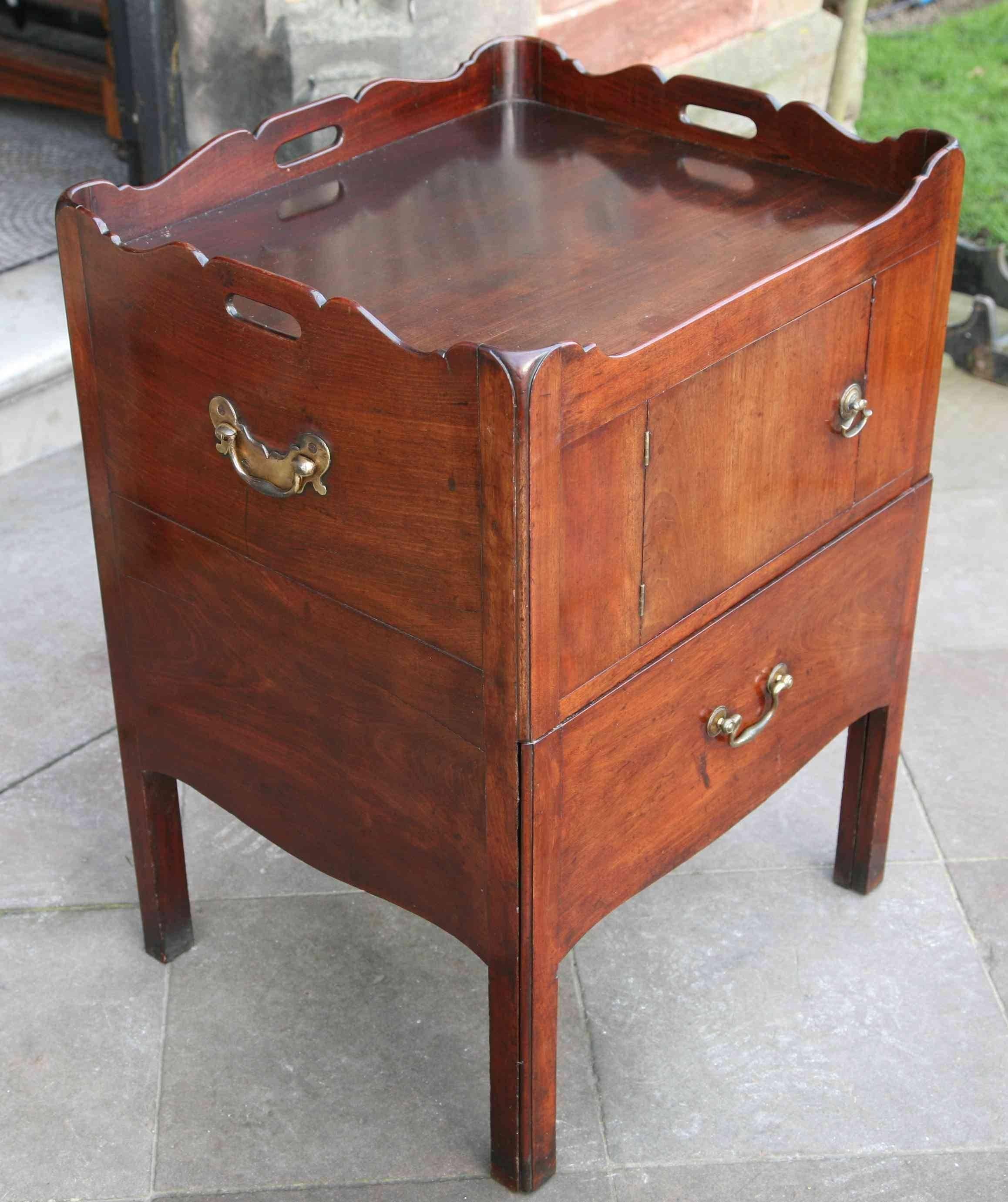 A good pair of George III mahogany tray topped bedside tables or commodes. Well figured mahogany tops with a pierced three-quarter gallery above the door, the pull-out base with a shaped apron now converted to a drawer, on square legs.