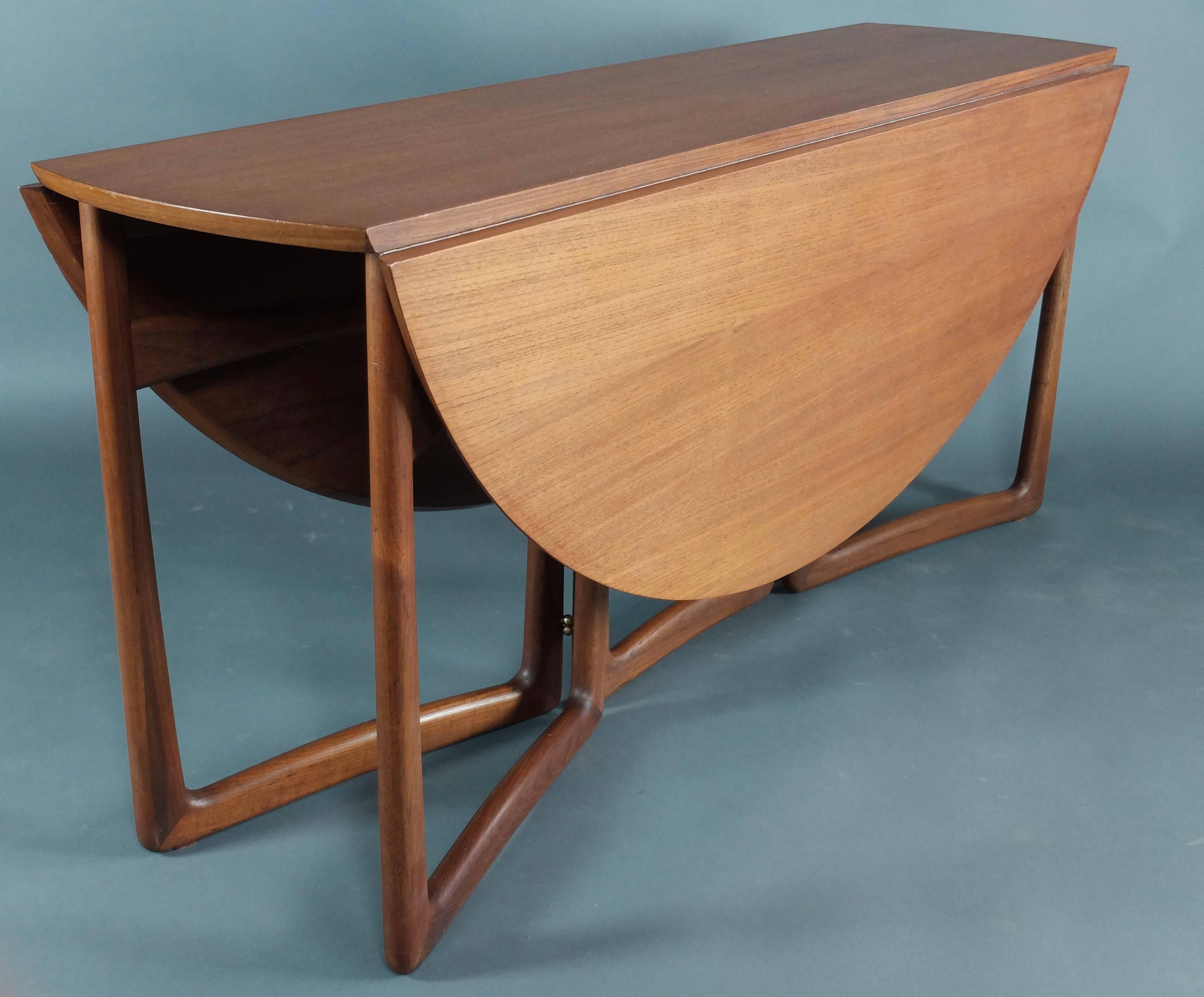 This Mid-Century dining table was designed by Peter Hvidt & Orla Molgaard Nielsen for France & Søn and manufactured in Denmark in the 1960s. This piece is made from teak with original sculptured legs, and features two extending drop leaves.