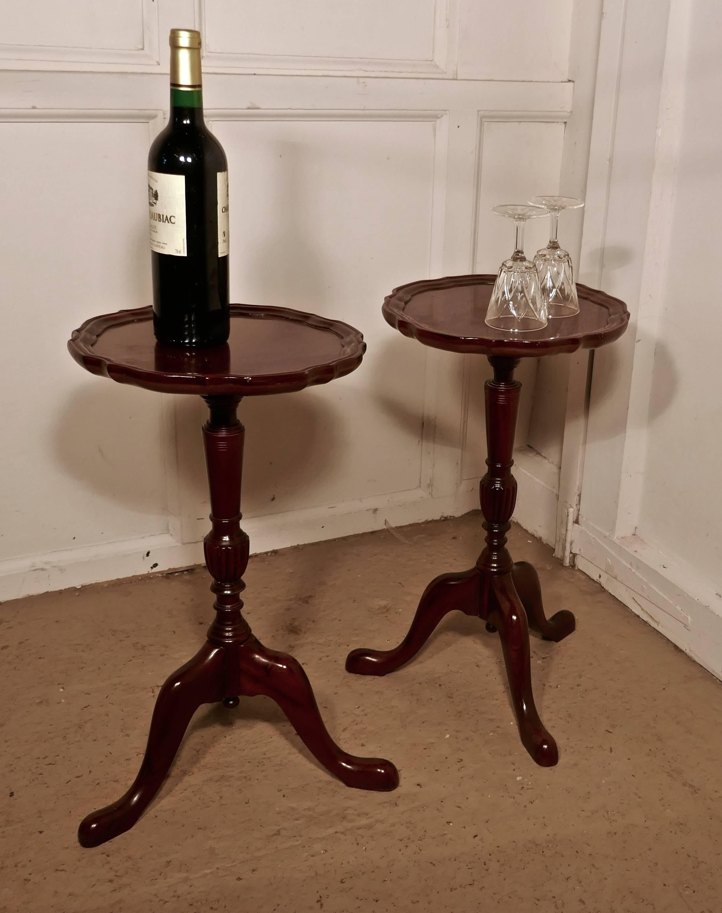 This is a very attractive pair of mahogany wine tables, they stand on a slender baluster three footed leg and they have a scalloped piecrust moulding around the edge of the tabletop 
The table are in good condition for their age and they have a