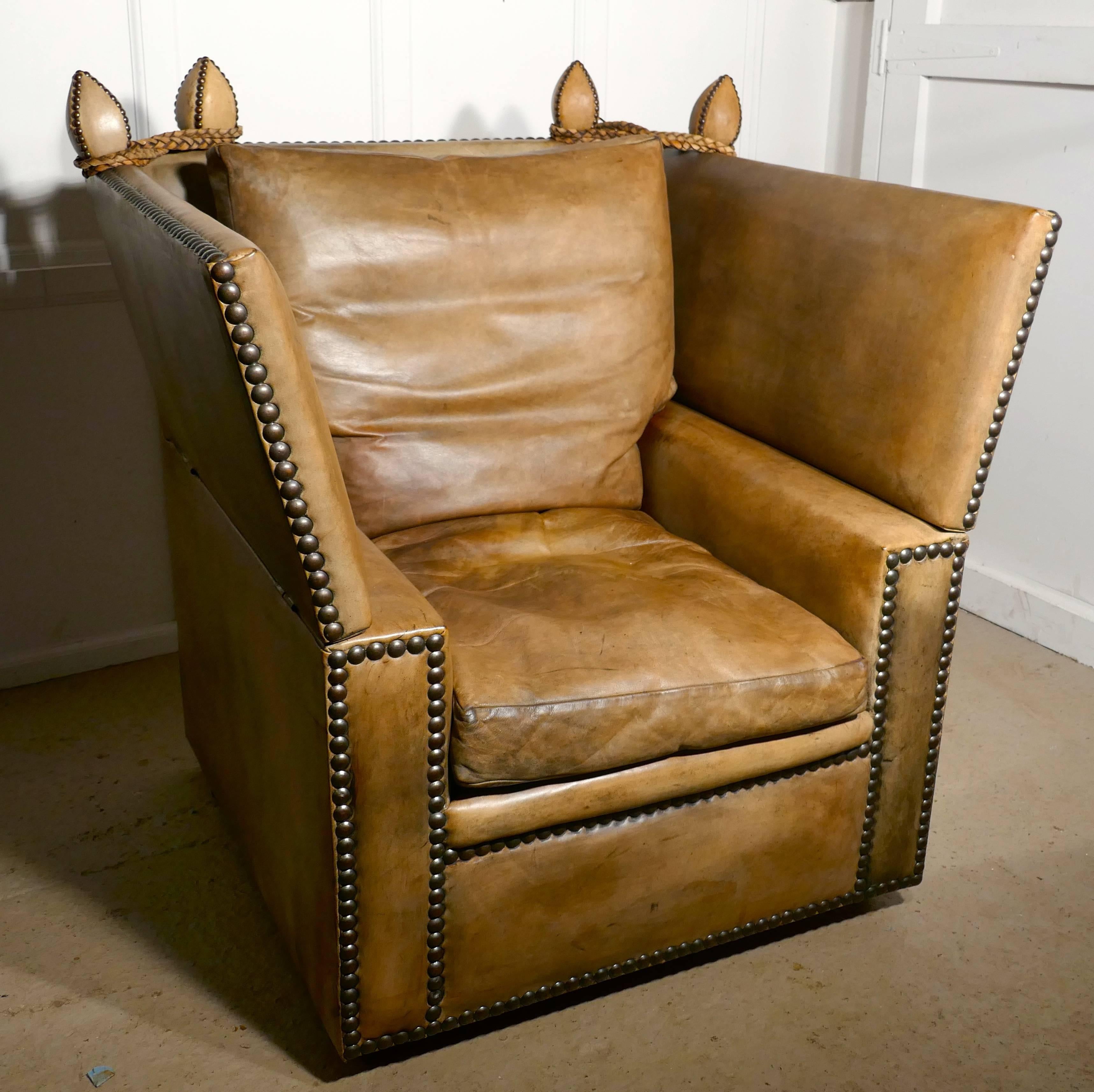 This is a very Large armchair, it is upholstered in its original leather with large brass studs, the leather is very thick heavy quality, and is very soft and pliable. The leather has faded with age and combined with the soft feather cushions it is