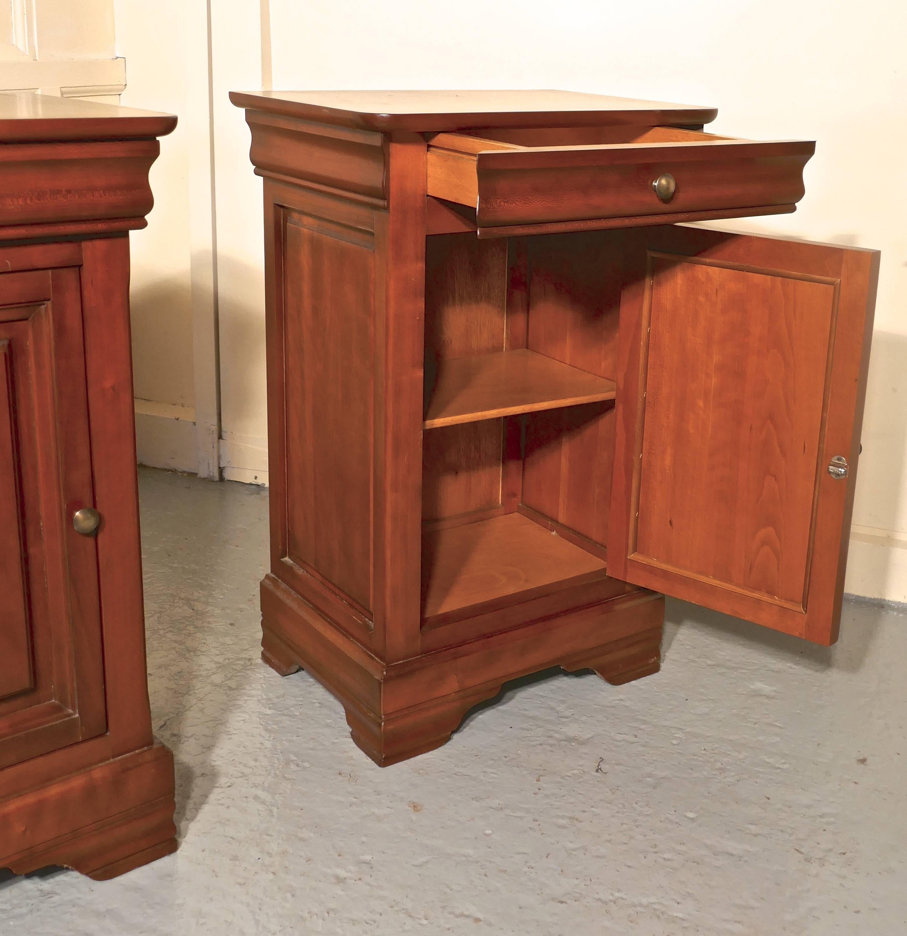 A pair of French cherrywood bedside cupboards or night tables

These are very attractive pieces they are made in well figured cherry, they each have a panelled Door to the front with a drawer over, there is a shelf inside, and they stand on a
