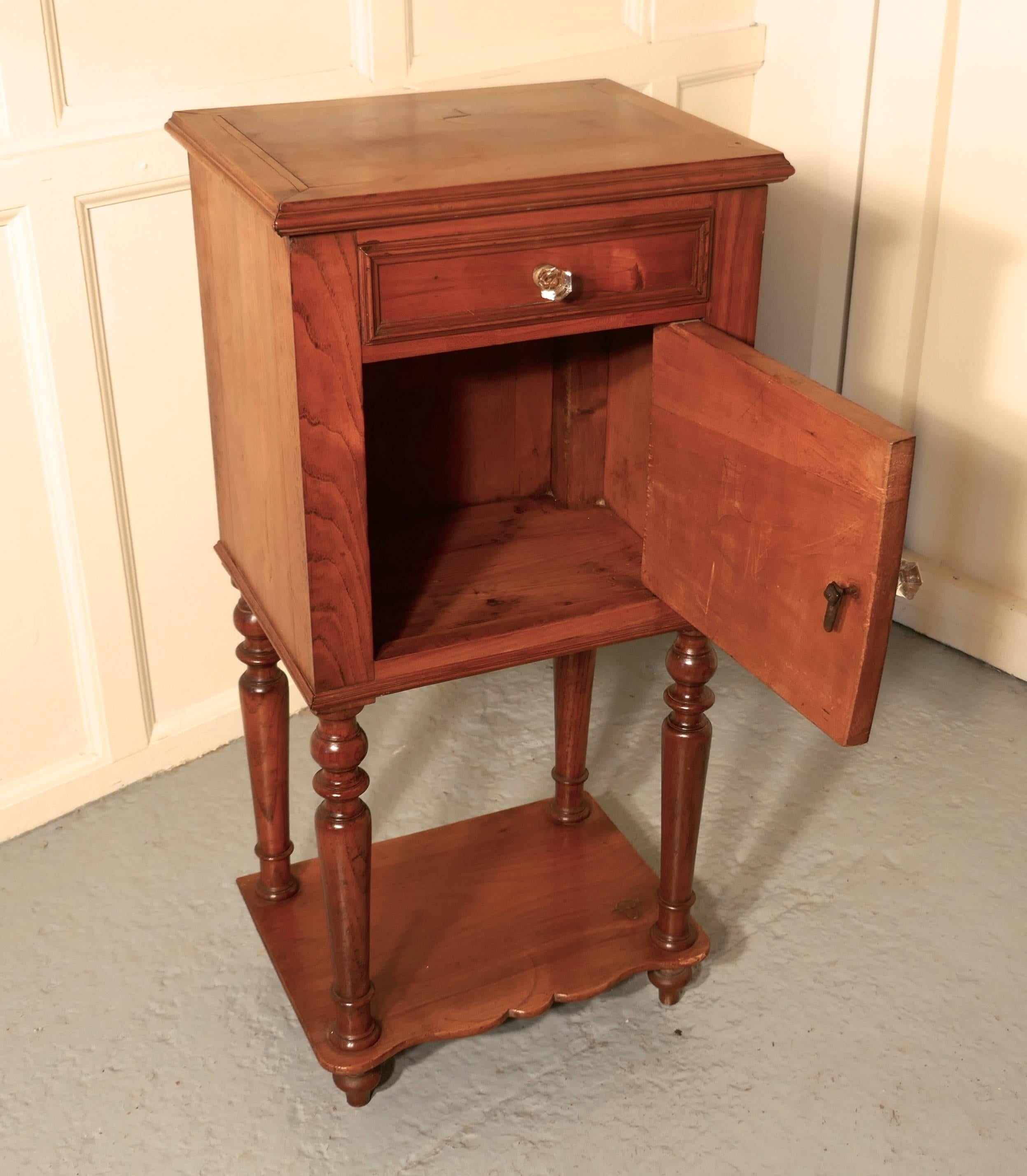 French 19th century cheerywood bedside cabinet 

This is a pretty French 19th century bedside cabinet, often known as chevet or night table in France
The cabinet dates from circa 1880, it is made from cheerywood and it stands tall turned legs, it