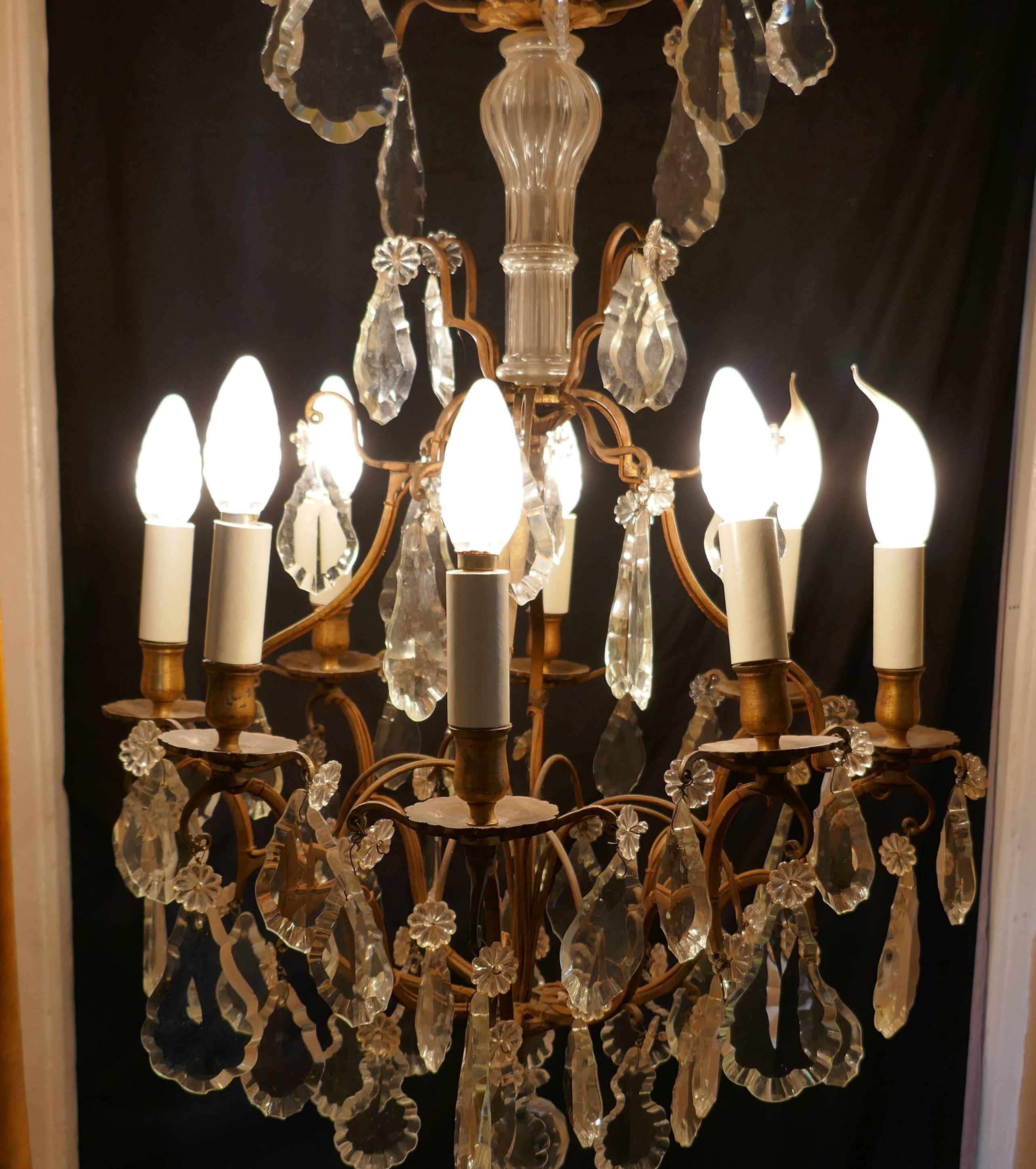 A stunning large French eight-branch chandelier

This is an excellent quality piece, it has a short glass baluster column at the top, 8 brass scrolling branches supporting brass sconces 
Each of the eight arms are hung sparkling crystal pendants,