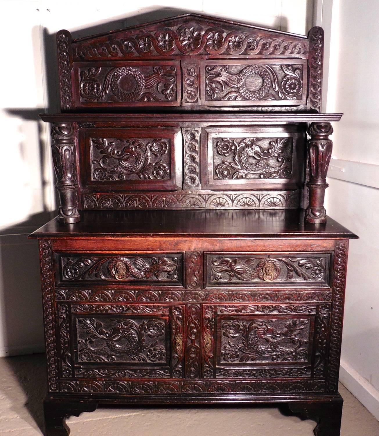 19th century carved welsh oak sideboard, dresser or hall cupboard 

This is a handsome piece with a wonderful patina, the carving is of very fine quality, the gargoyles carved on every panel, depict Dragons and fierce serpents
The dresser has a