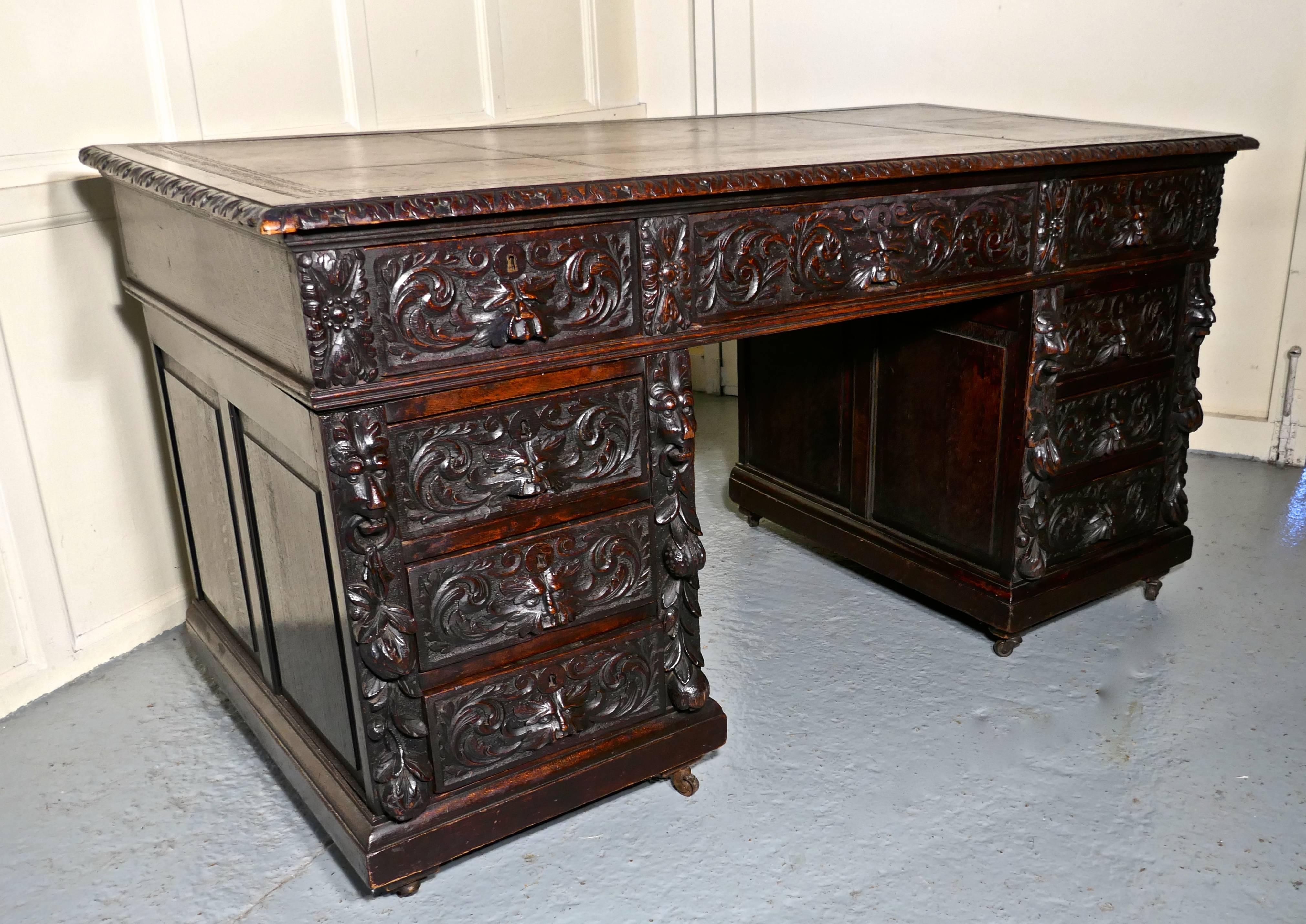 A superb large Victorian green man carved oak pedestal desk
 
This is a good large Victorian desk, made in oak which has been superbly and intricately carved with the masks of Lions or perhaps the green man. 
The top has its original inset light