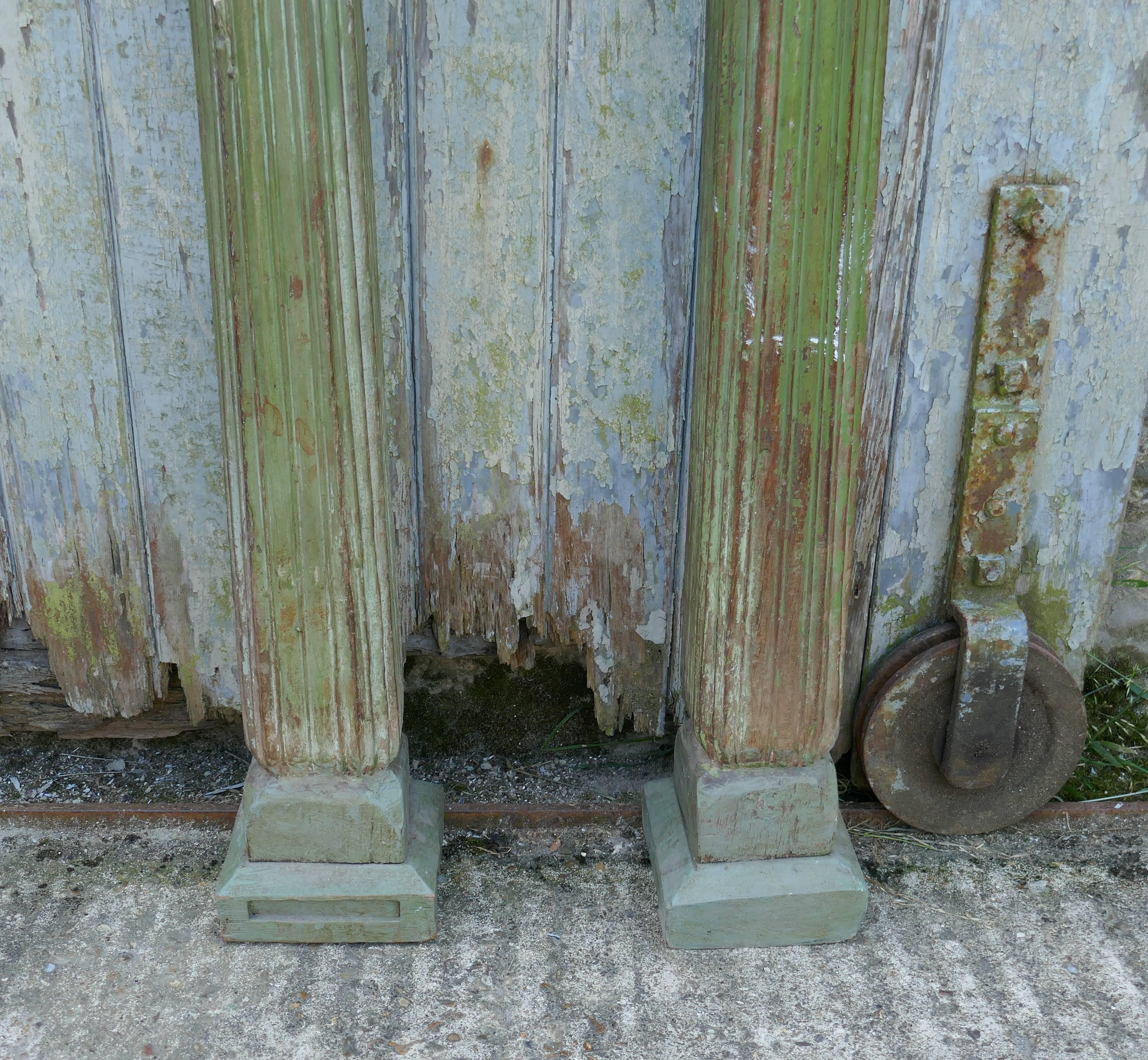 A pair of antique carved and painted Corinthian type columns.

These are a very tall pair of carved wooden pillars, they are in their original mossy green paint 

The columns are reeded in the Greek style with decorative scroll pediments, the