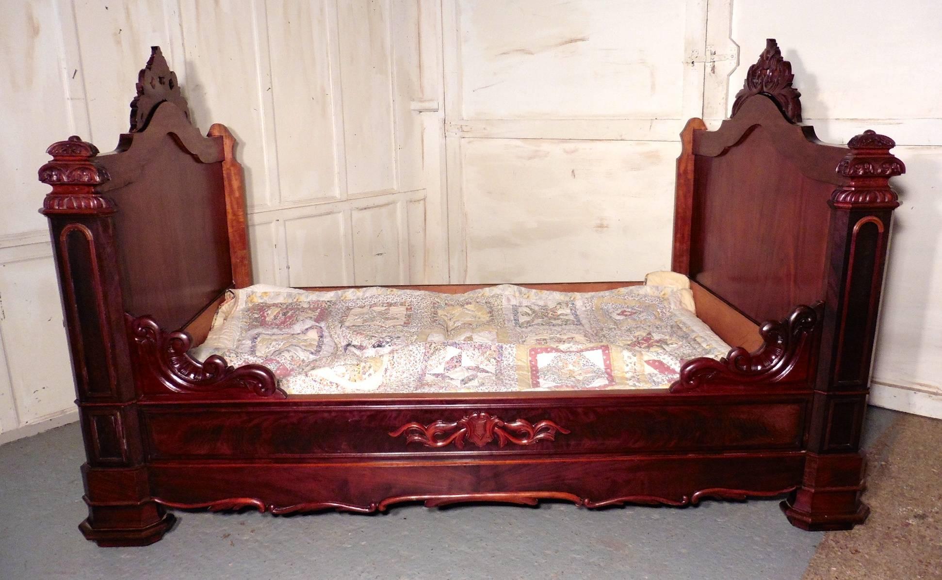 French flame mahogany and walnut sleigh bed or Empire style daybed

This is a large sleigh bed or Empire style daybed, which would look fantastic piled up with comfy cushions.
Both ends are the same height with a rounded top rail and an elaborate