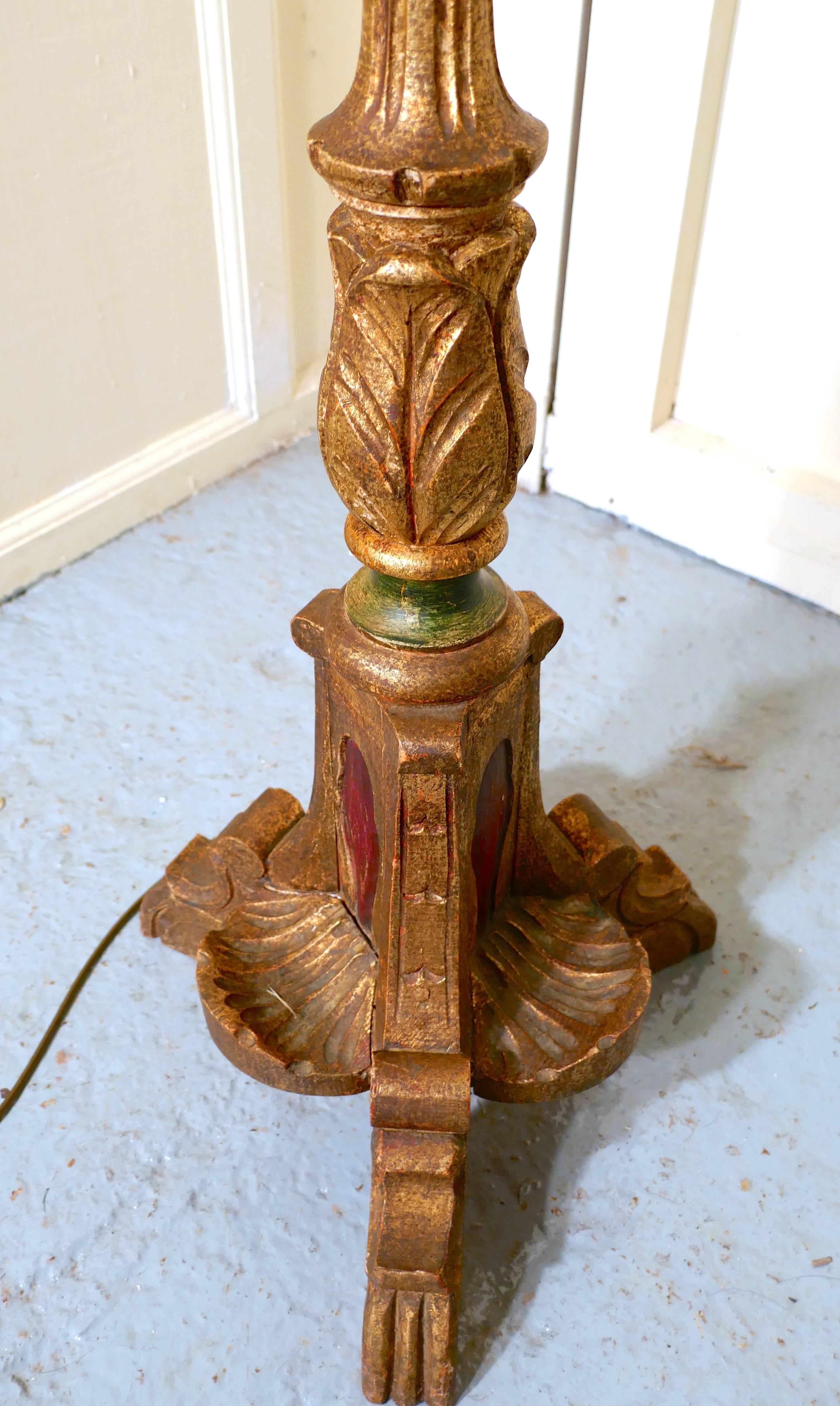 French carved gilt floor standing or standard lamp

This is an attractive piece in age darkened gold with green and red colored panels, the lamp stands on a carved three-footed base and has an elaborately carved upright column with an imitation