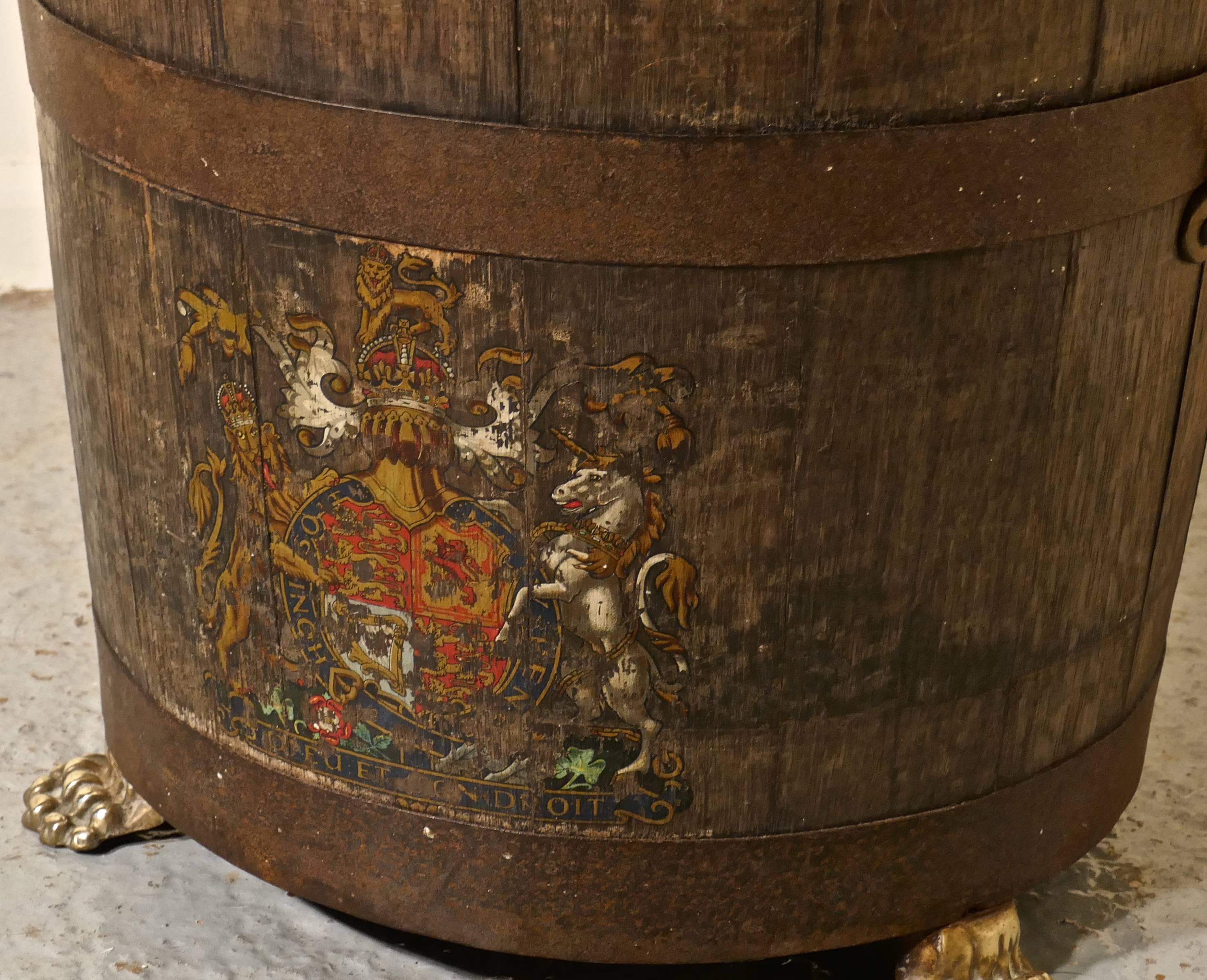 An oak iron bound ships barrel, with the royal coat of arms

This lovely old piece it is made in oak and decorated with the royal coat of arms, the barrel stands in three small brass hairy paw feet and it has brass carrying handles
The barrel