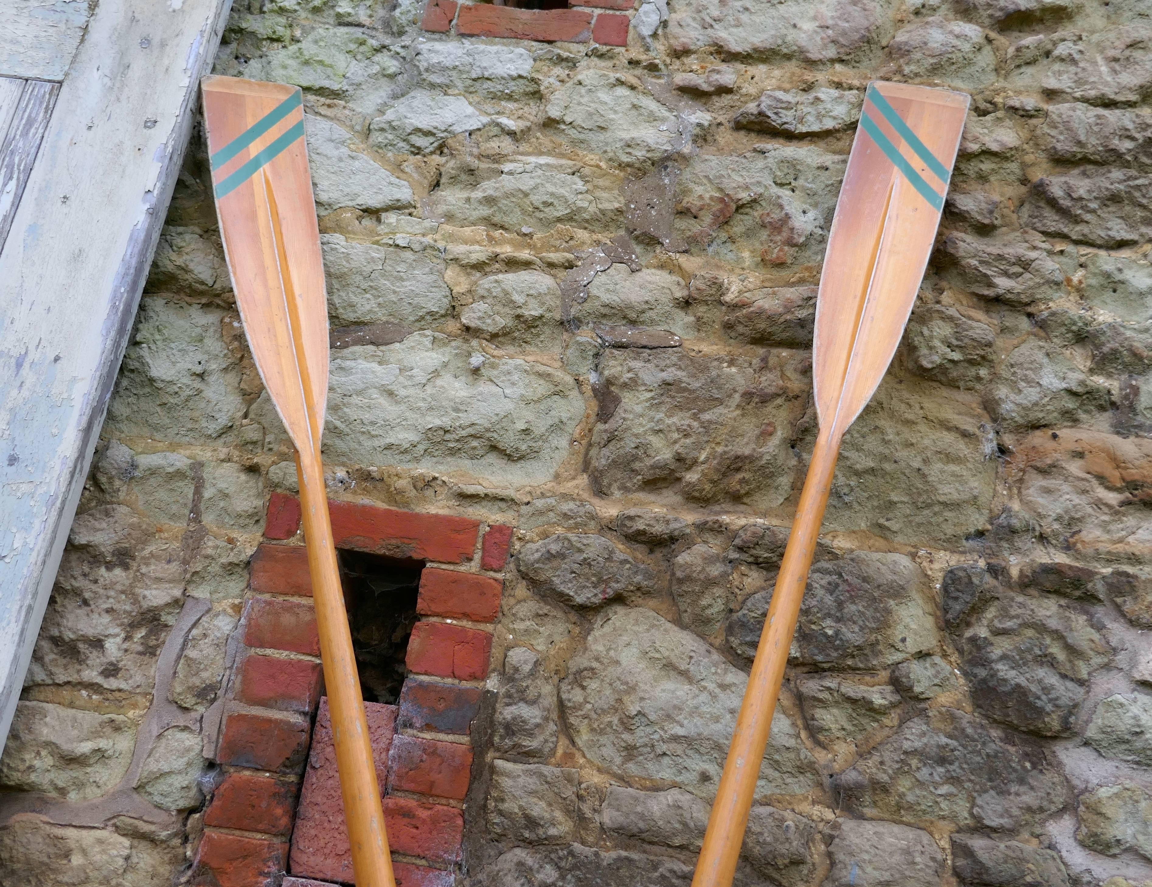 A pair of decorative very long sculling oars

This is a fine quality pair of long oars from a Thames Rowing Club, the spoons or blades have diagonal green parallel lines painted on them and the long ash shafts are in their original varnished