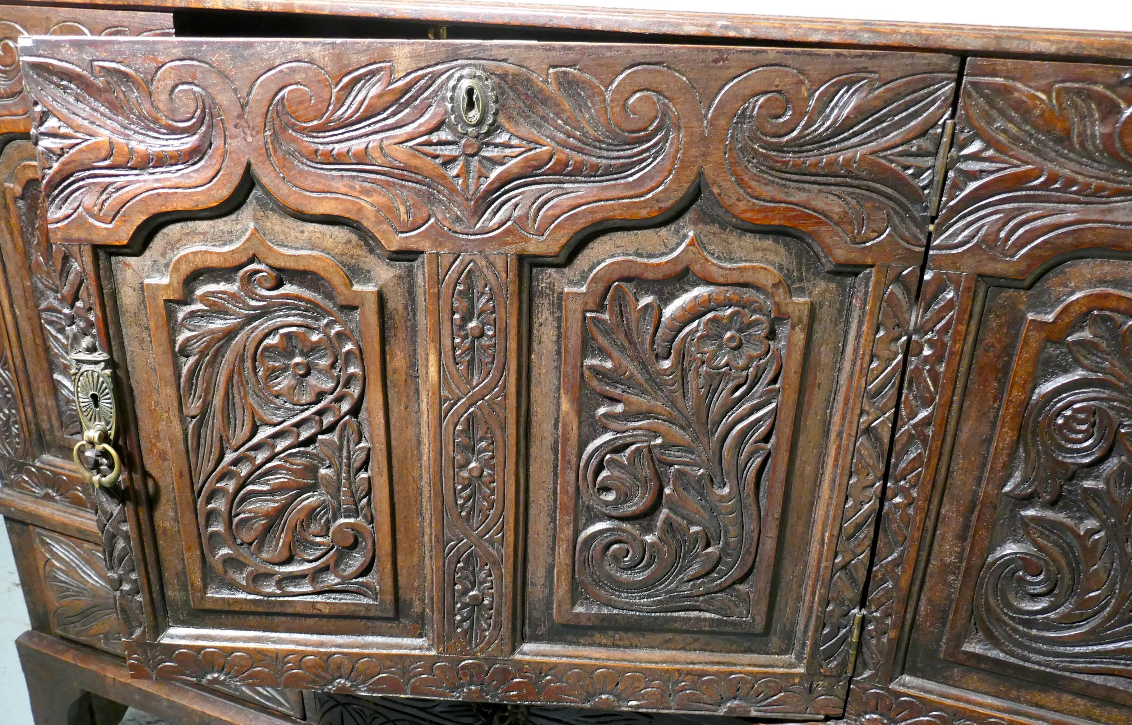 Large 18th Century Carved Oak Marriage Chest 

This is a lovely old piece, originally a Mule chest has been converted into a much more practical sideboard with a front opening door. This has been done by having the centre panel placed on hinges to