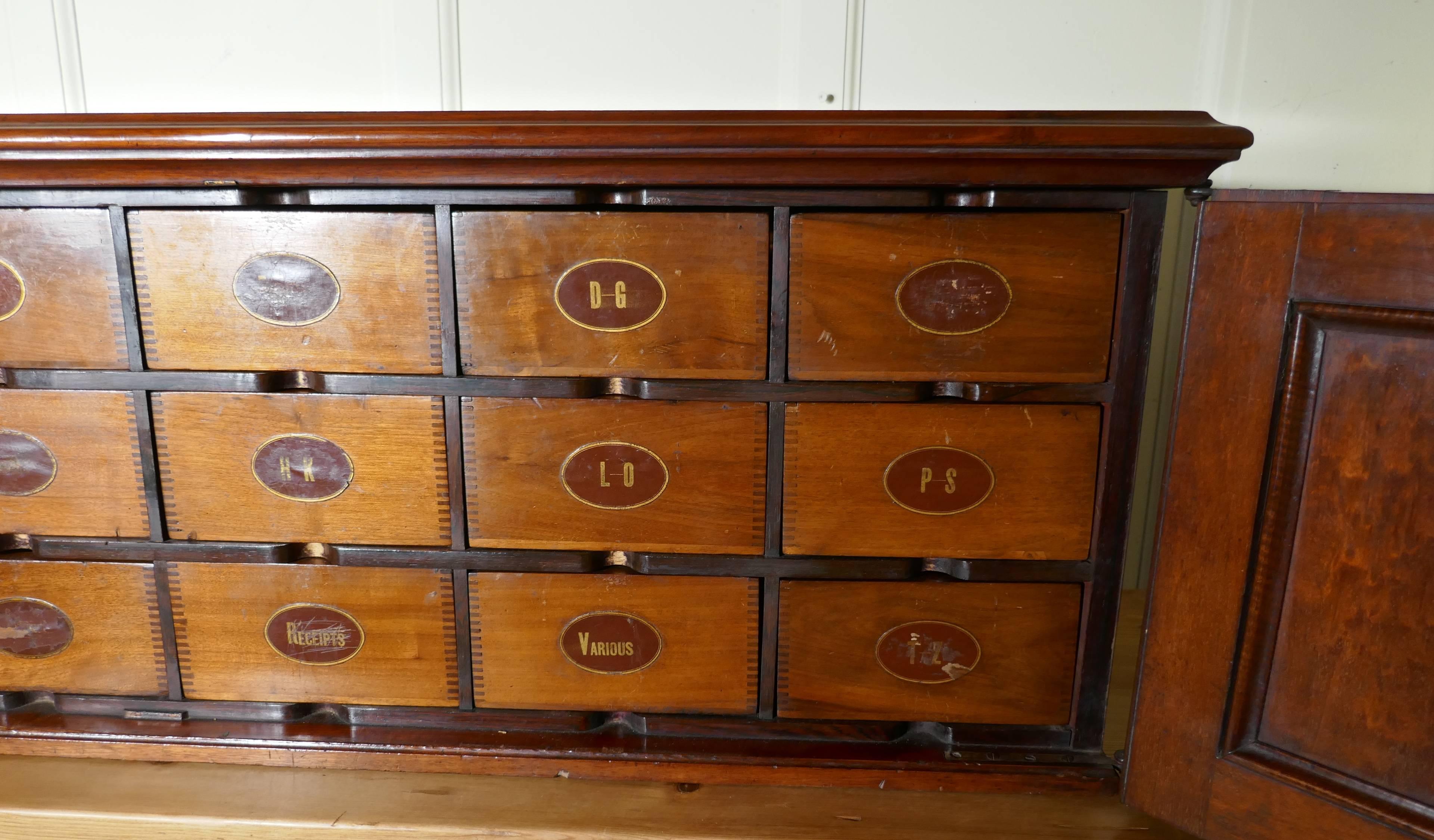 19th century long mahogany estate cupboard filing drawers 

This long cabinet is a very fine quality piece it is freestanding and has four panelled doors enclosing 21 filing drawers, some of which still have there spring clips which allows them to