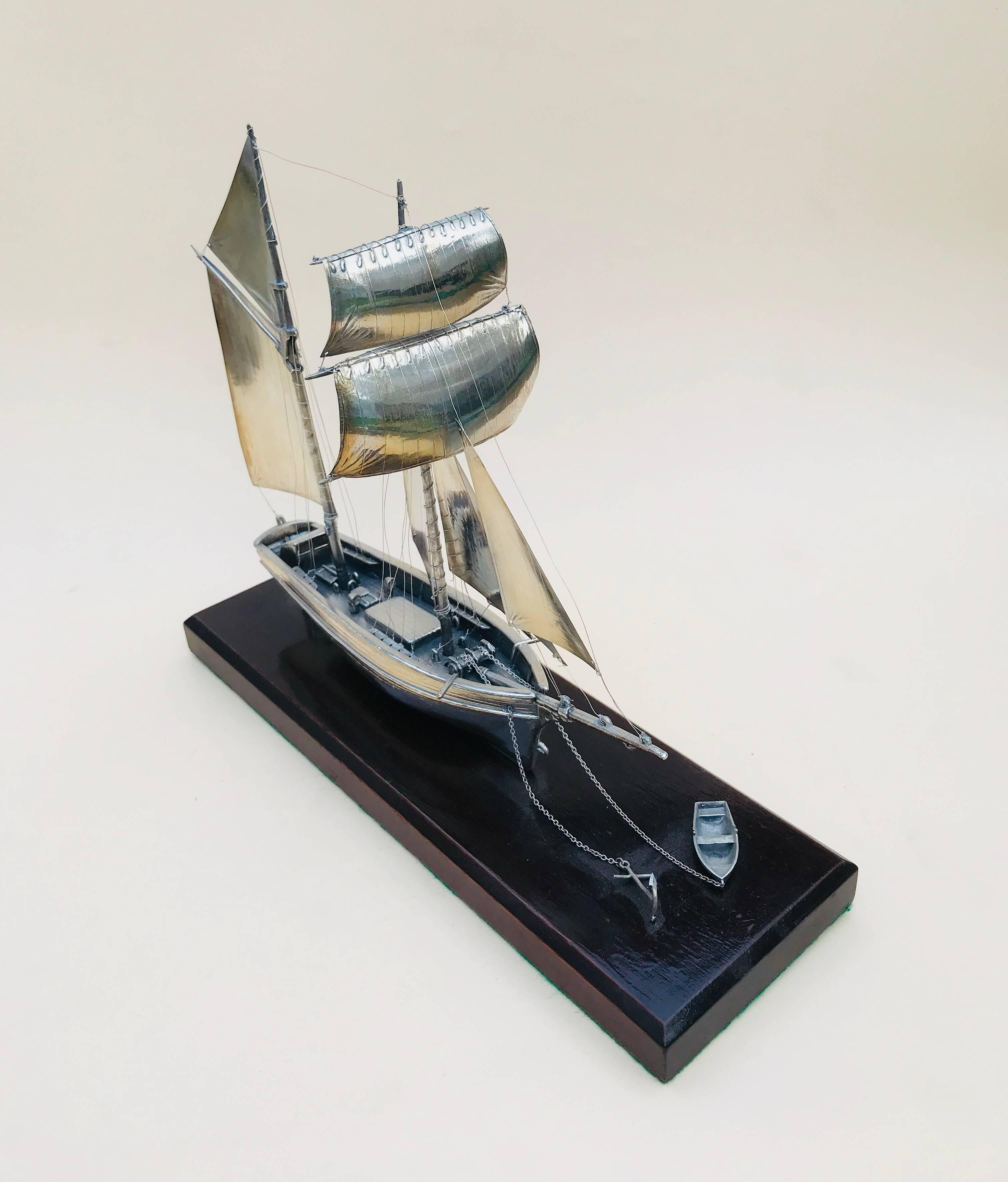 20th century silver twin masted yacht desk, ornament 

This is a lovely piece from the latter part of the 20th century, in the finest detail this is a fully articulated twin masted yacht.
The Yacht has eight sails in all, a small tender dinghy