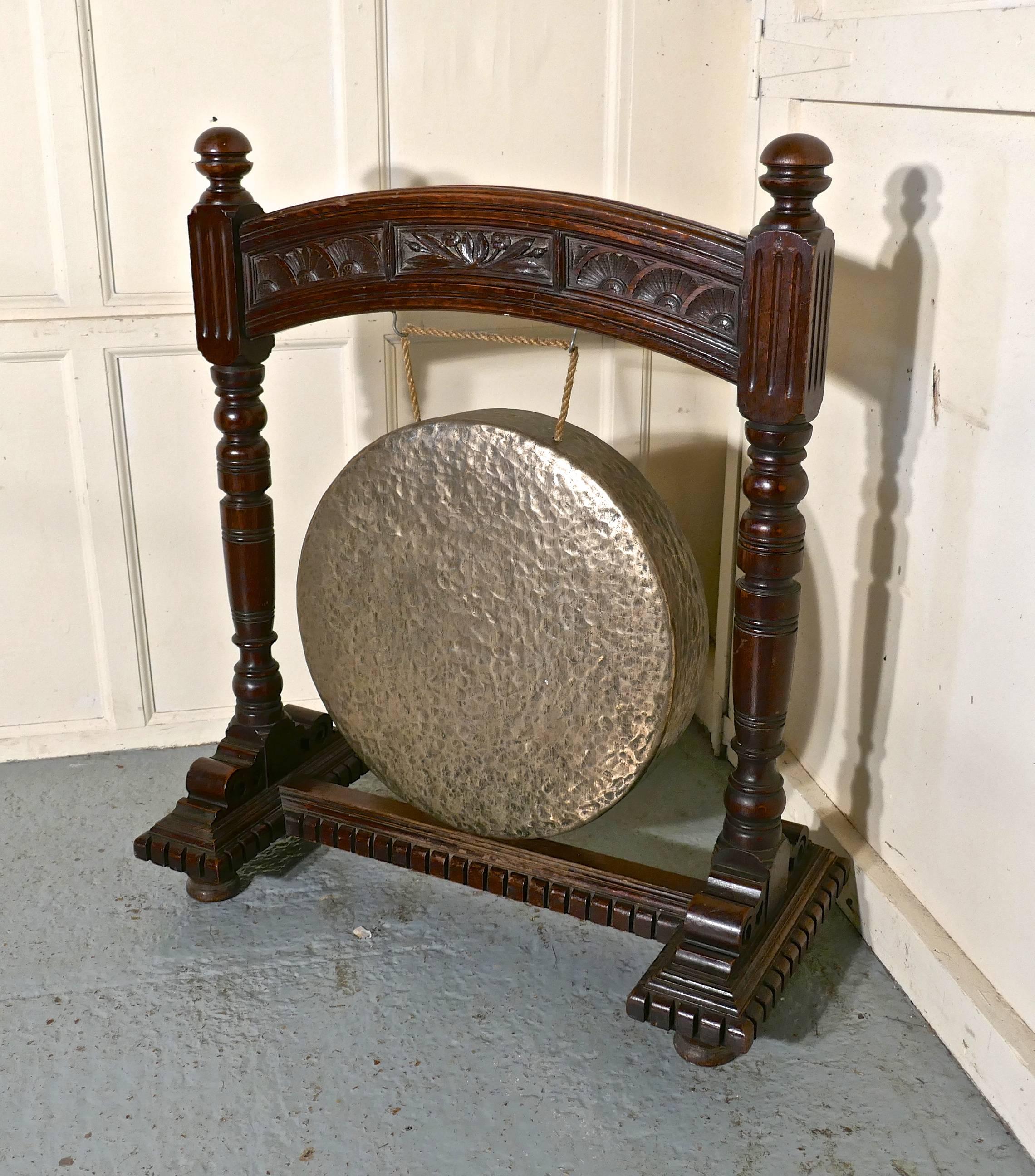 A large gothic carved oak and brass dinner gong
 
This is a large piece the large heavy brass Gong is suspended in an attractive and sturdy carved oak stand, with a carved base and standing on bun feet, the Brass Gong has good deep sound and will